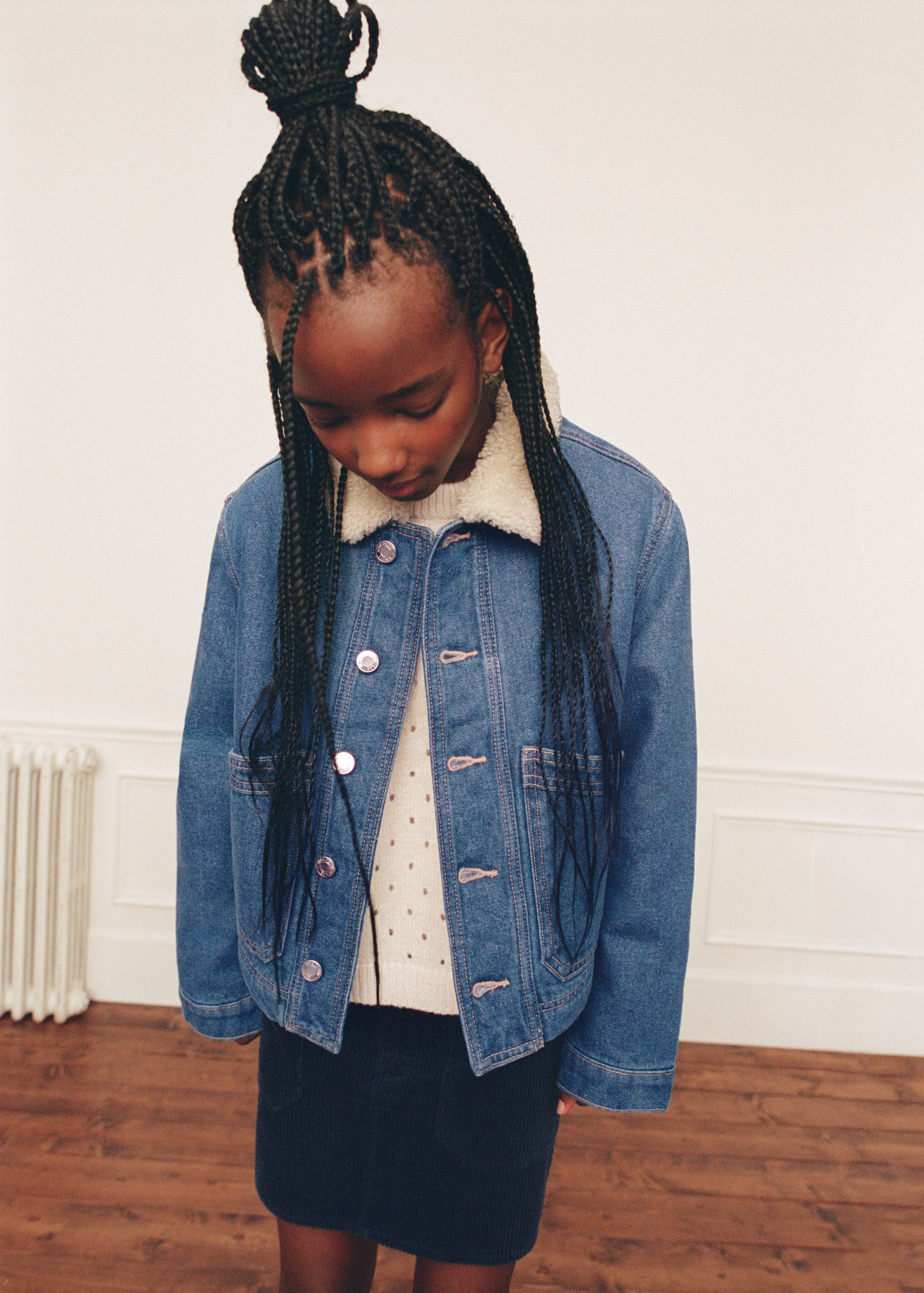 Dark blue skirt worn with a denim jacket and cream knit jumper.