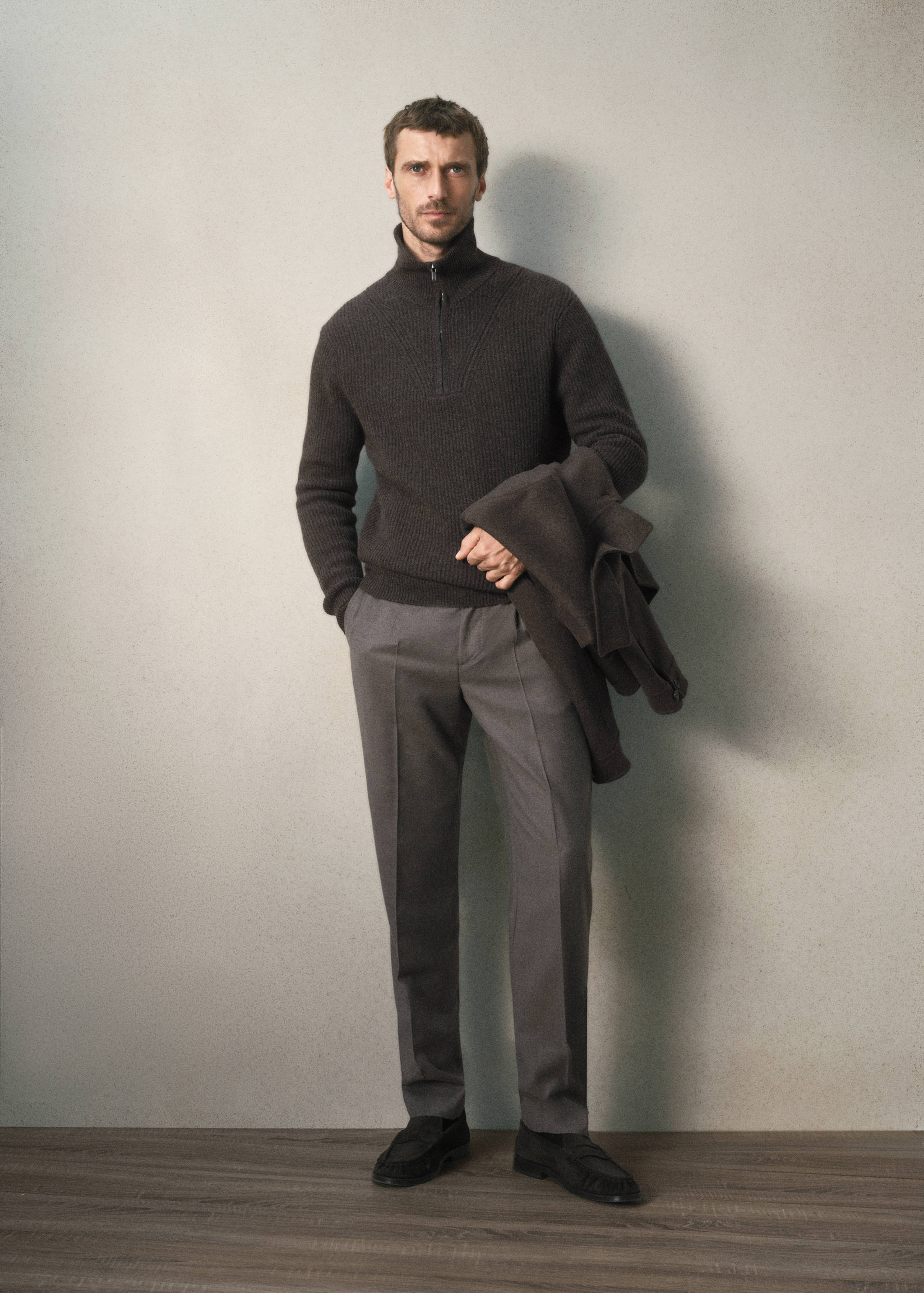 Dark brown ribbed knit zip-collar jersey worn with grey trousers