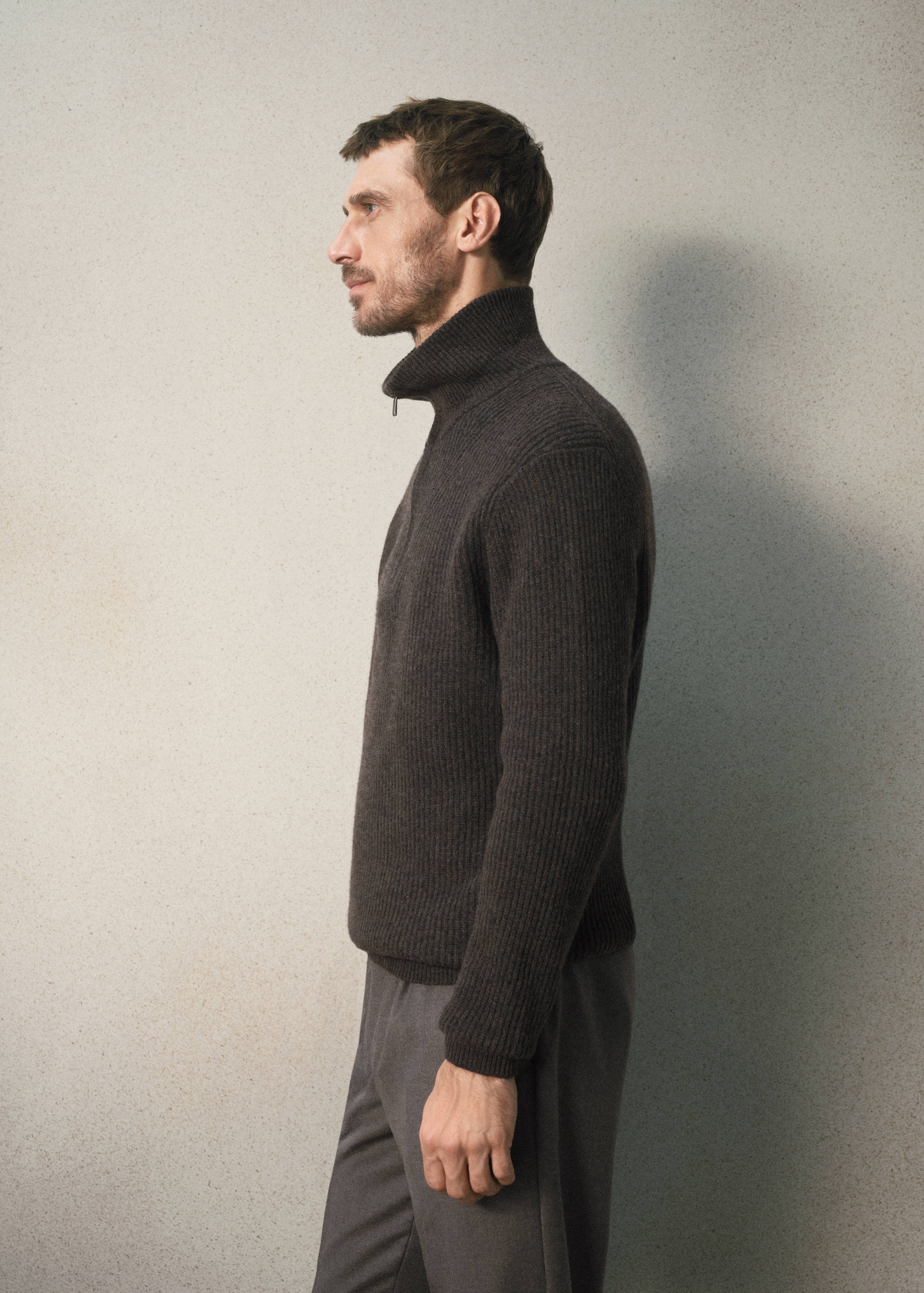 Dark brown ribbed knit jersey with a high zip-neck collar.