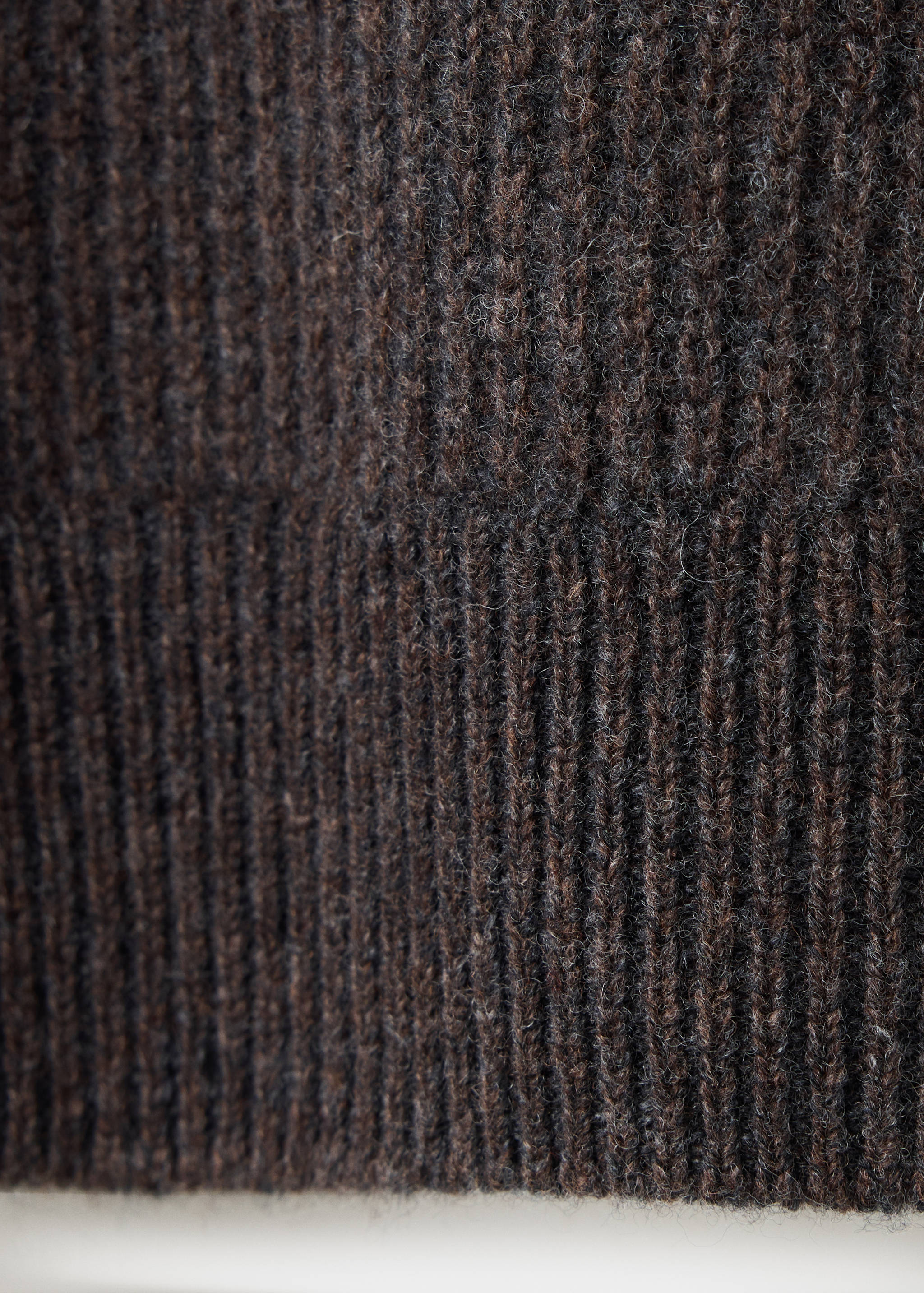 Close-up of a dark brown ribbed knit sweater showing its textured pattern.