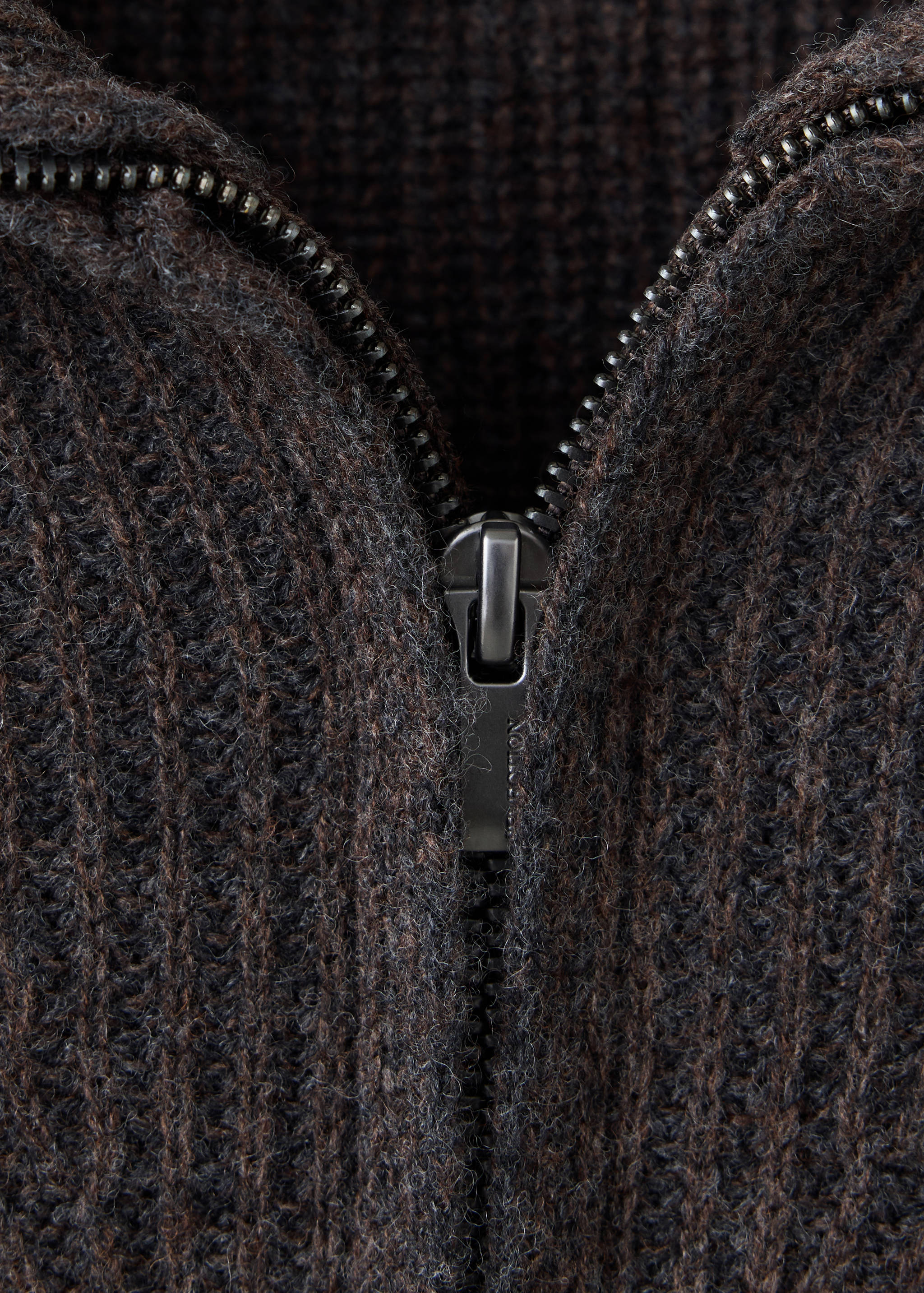 Close-up of a brown ribbed knit jersey with a metal zip.