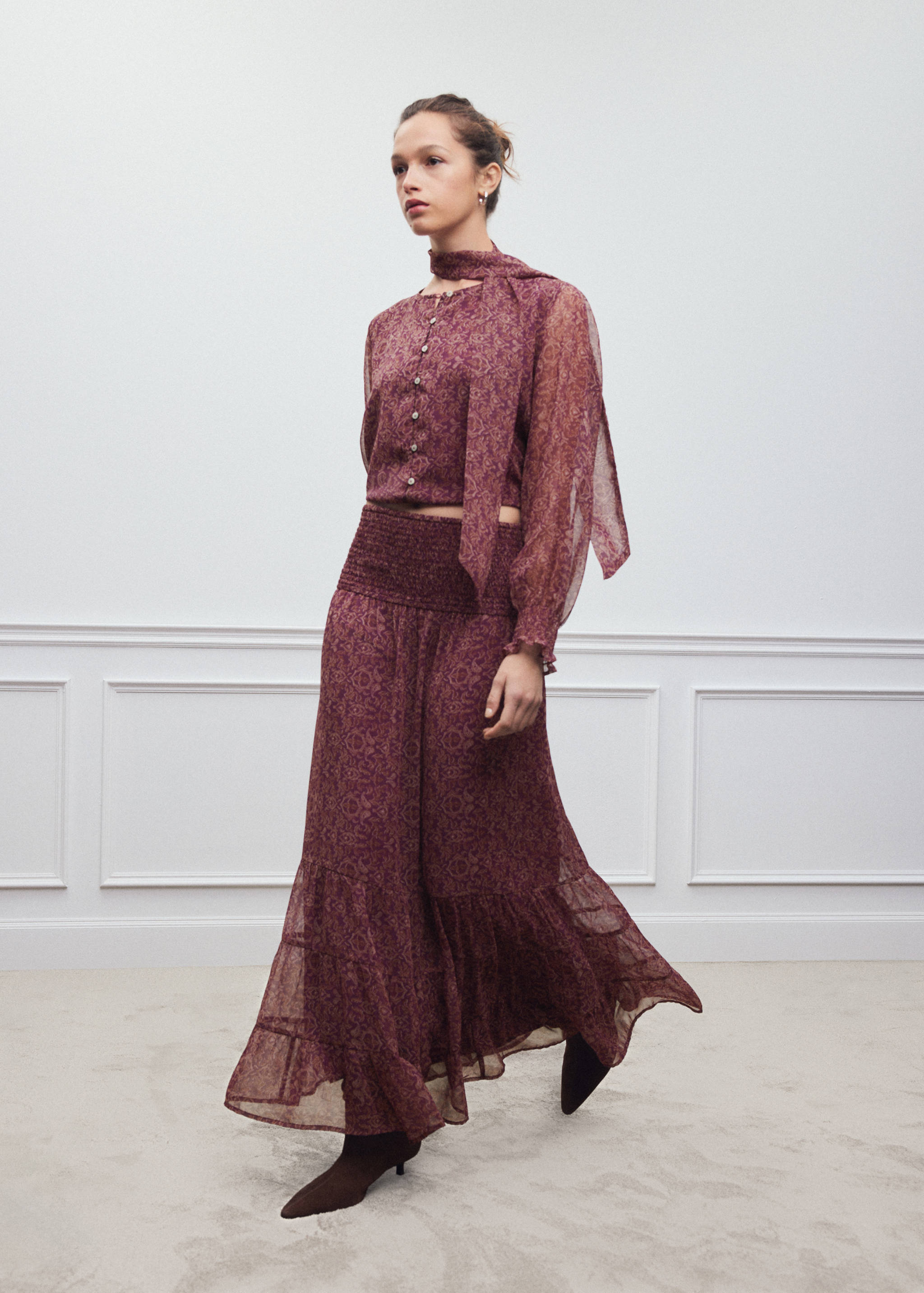 Burgundy printed long skirt with a wide smocked waistband and tiered hem.