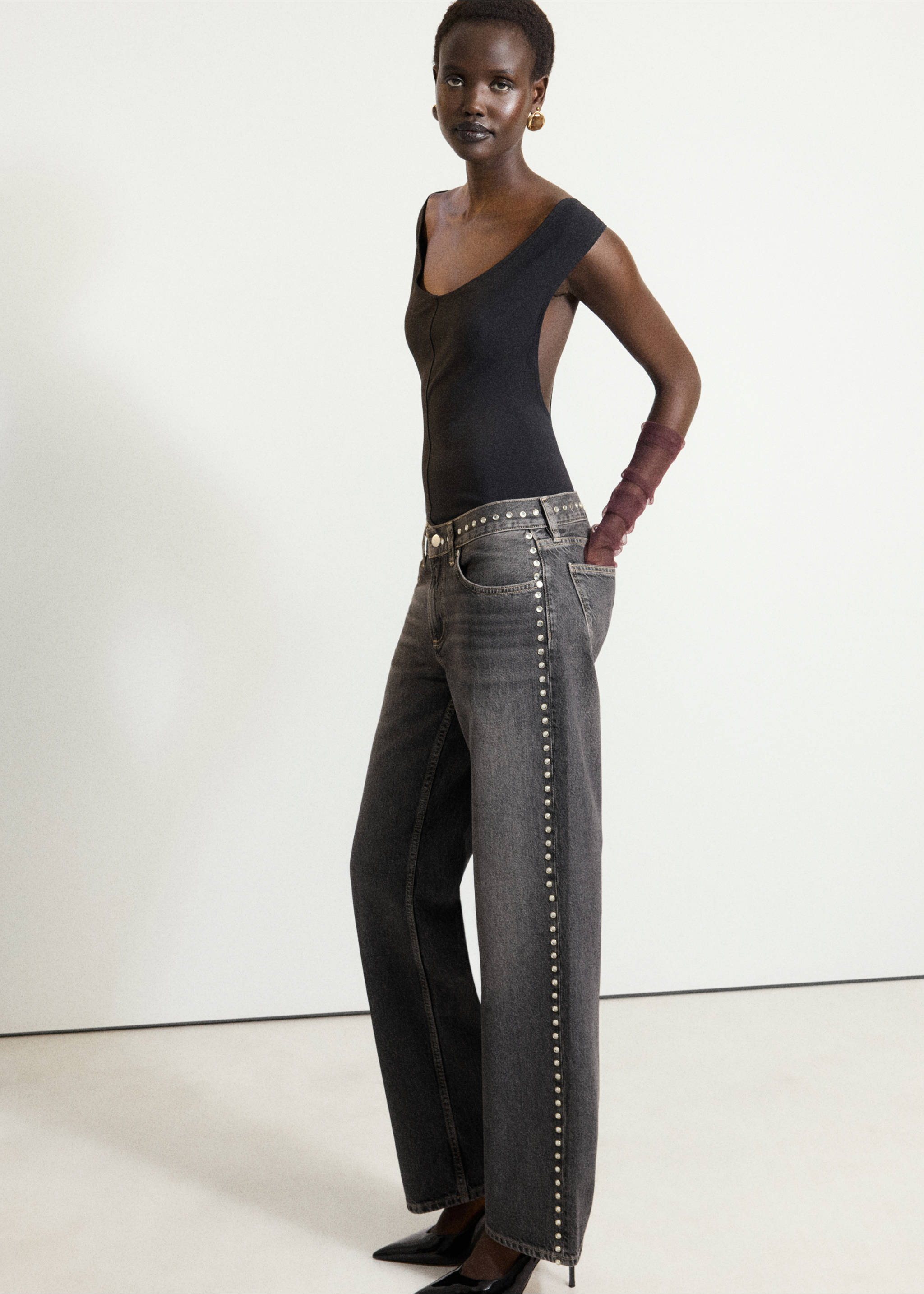 Pantalones vaqueros de denim gris oscuro con tachuelas metálicas en las costuras laterales, combinados con un top negro sin mangas., Gris. Ref: 37098286-00.