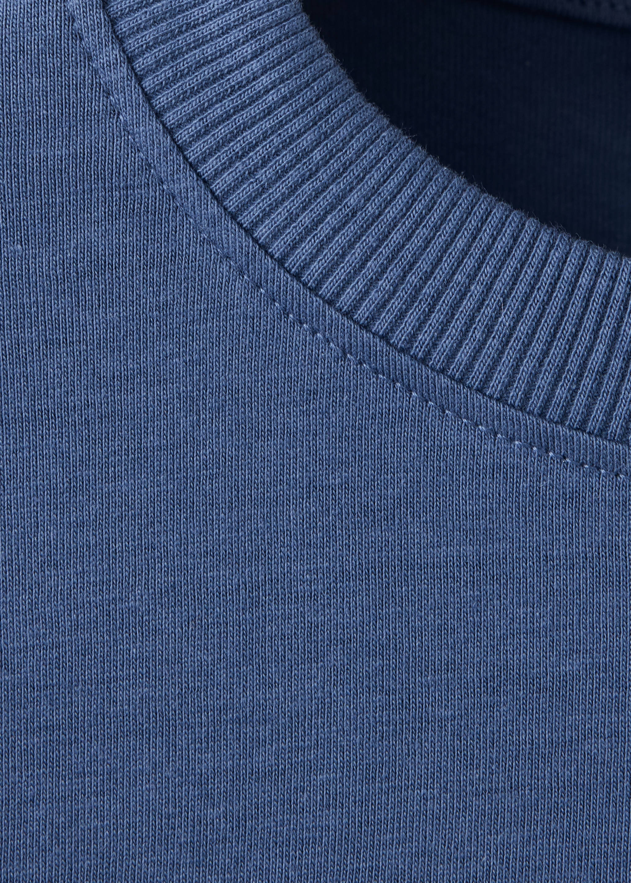 Close-up of a blue children's t-shirt with a ribbed round neckline.