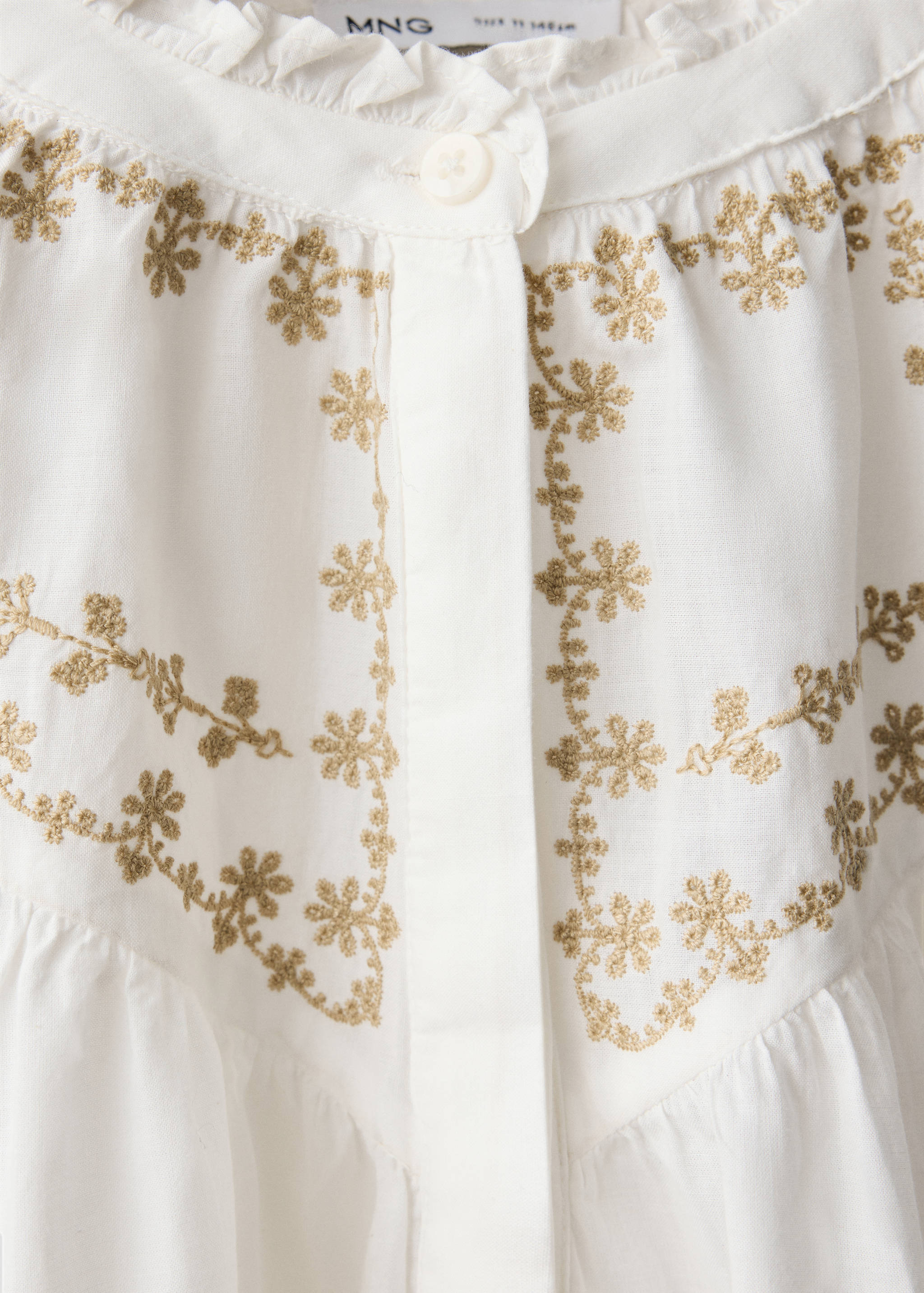 White kids' shirt with a ruffled collar and gold floral embroidery detail.