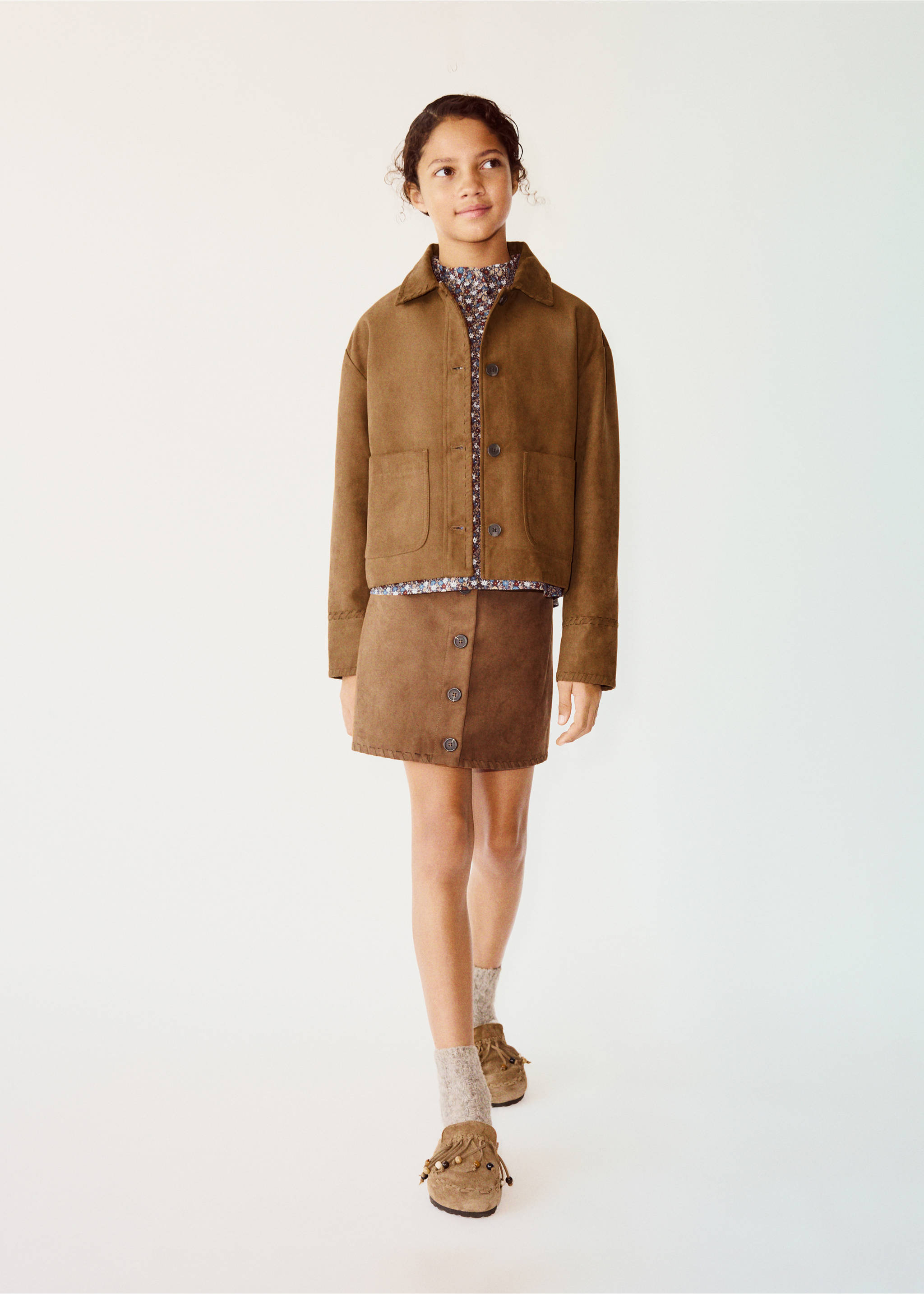 Brown skirt worn with a matching jacket, patterned blouse, and brown shoes., Brown. Ref: 37098635-00.