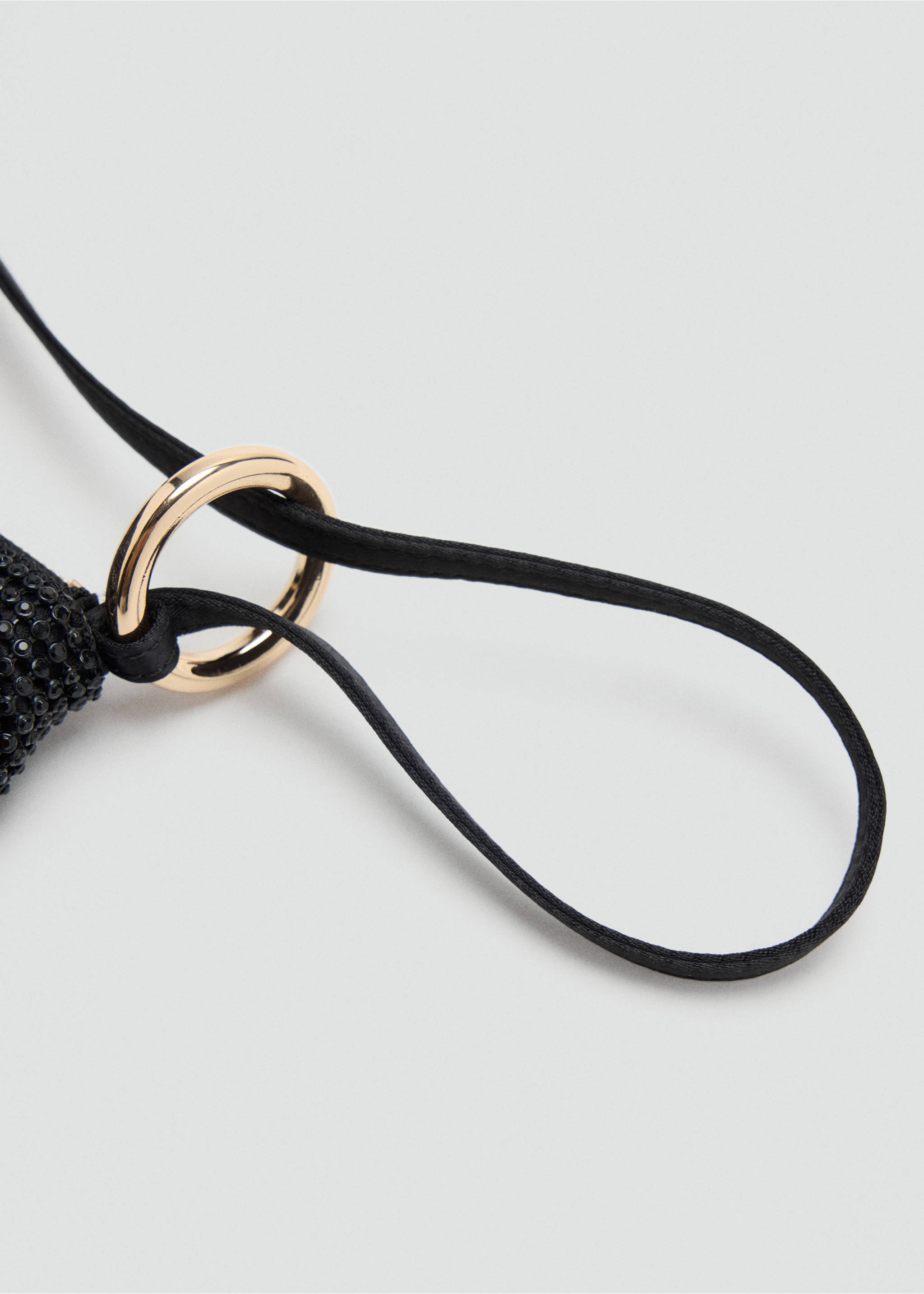 Close-up of a black handbag strap and gold-tone metal ring detail., Black. Ref: 37099113-00.