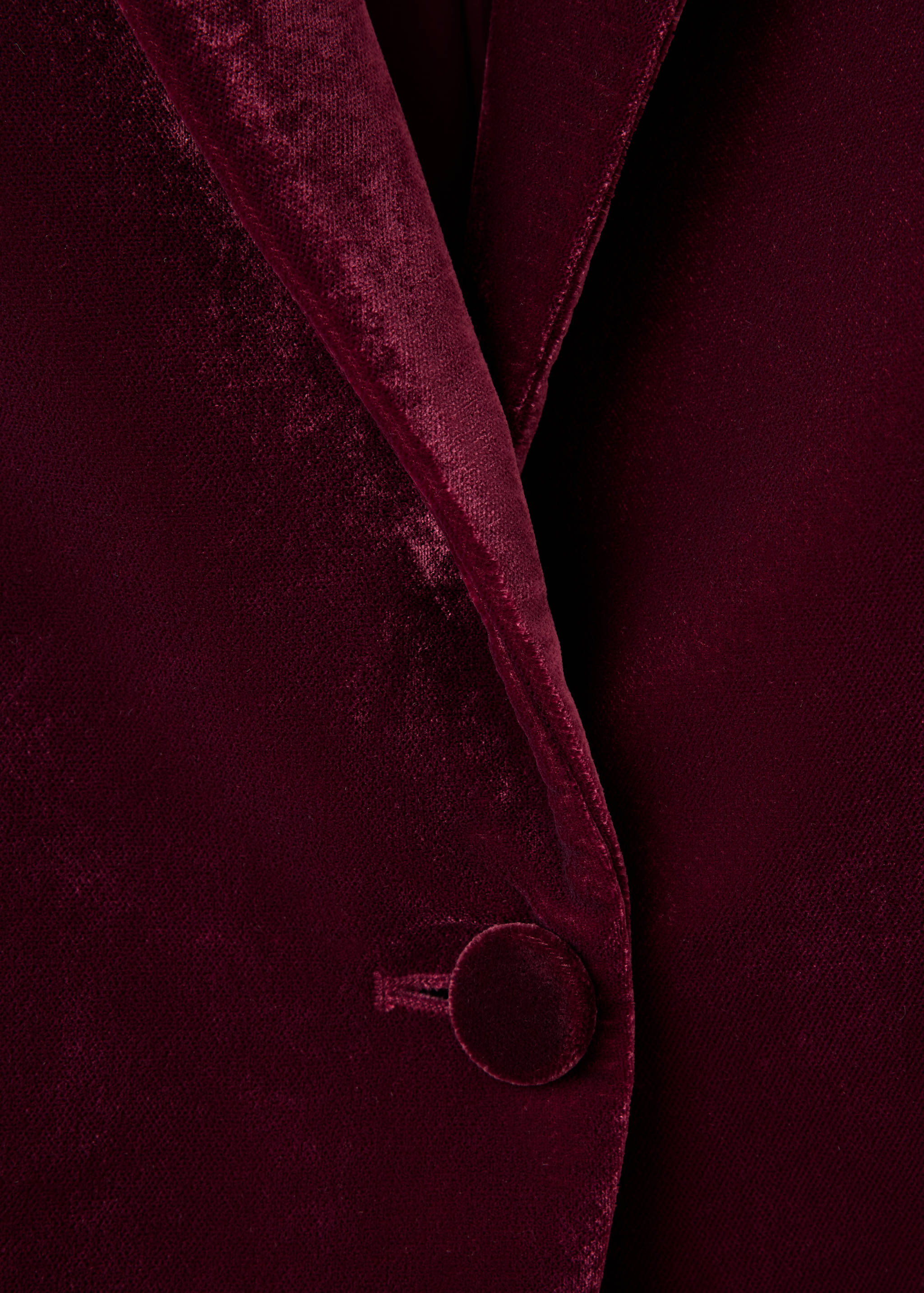 Primer plano de blazer de terciopelo burdeos, que muestra la textura y la solapa.