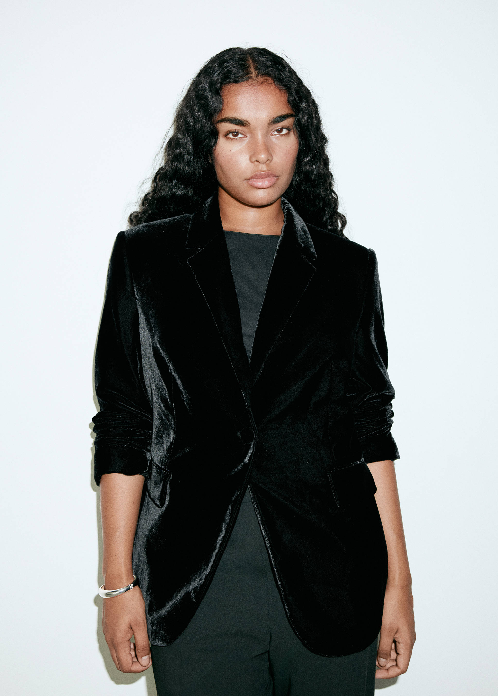 Blazer de terciopelo negro con solapas de muesca y bolsillos con solapa.