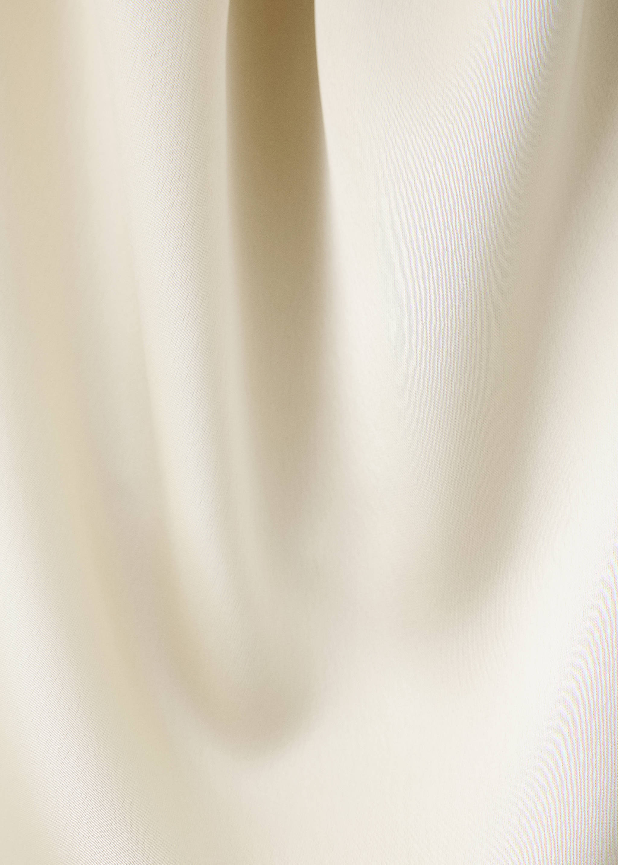 Close-up of white top fabric showing smooth texture and soft folds.