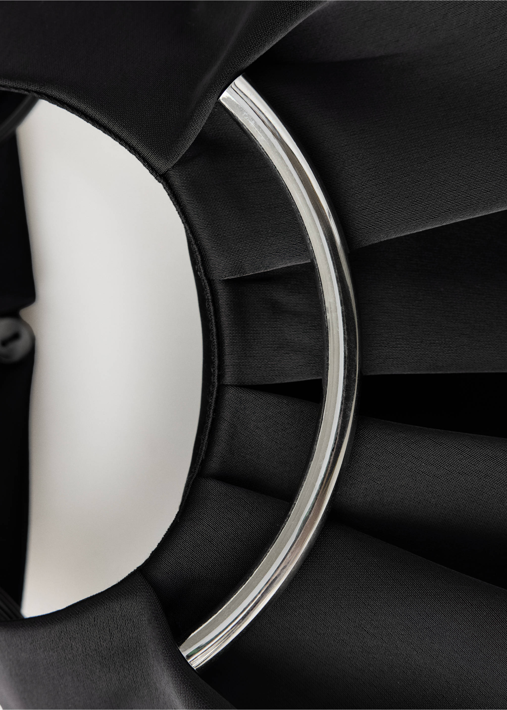 Close-up of a black top with a metallic ring neck detail., Black. Ref: 37099116-00.