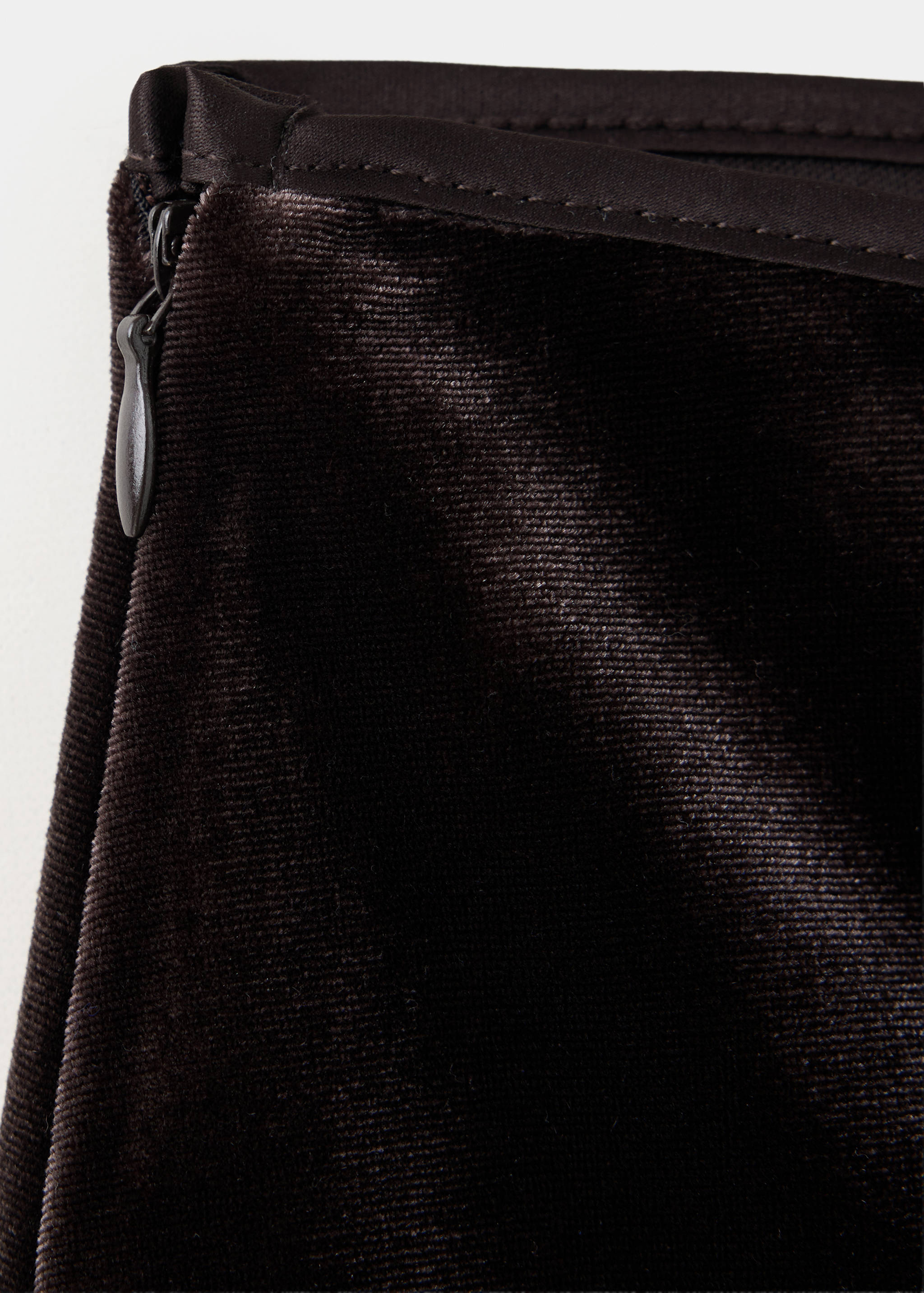 Close-up of the dark brown velvet skirt fabric and side zip.