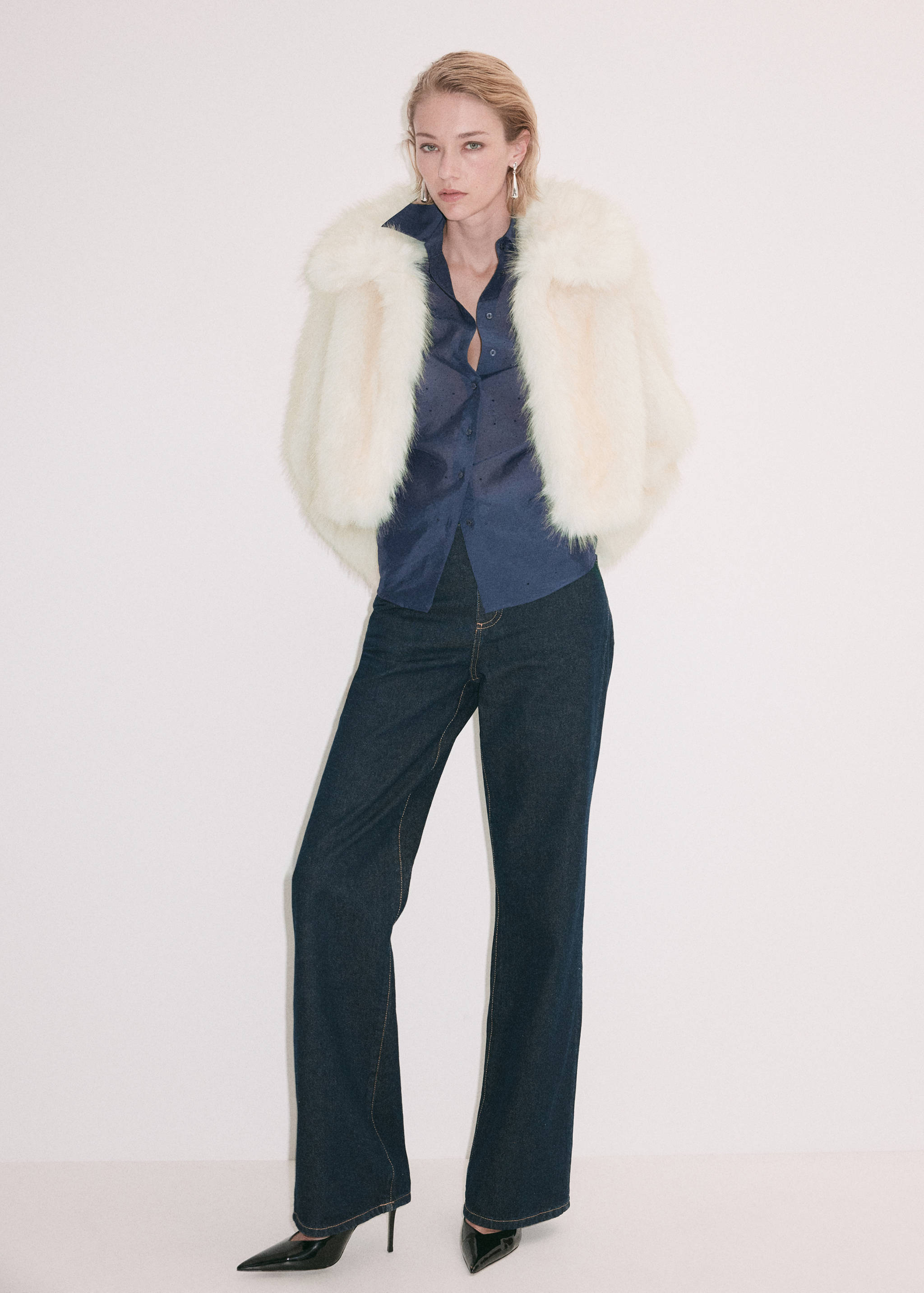 Dark navy blue button-up shirt with collar, worn with a white faux-fur jacket.