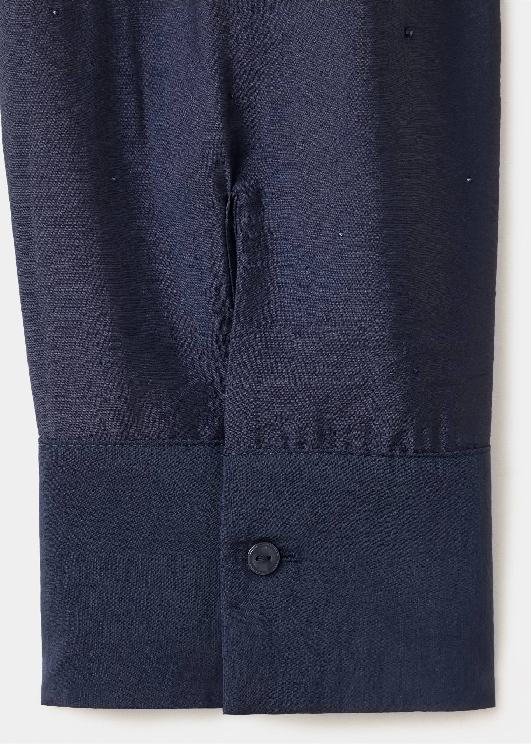 Close-up of a dark navy blue shirt cuff and beaded fabric texture., Blue. Ref: 37099118-00.