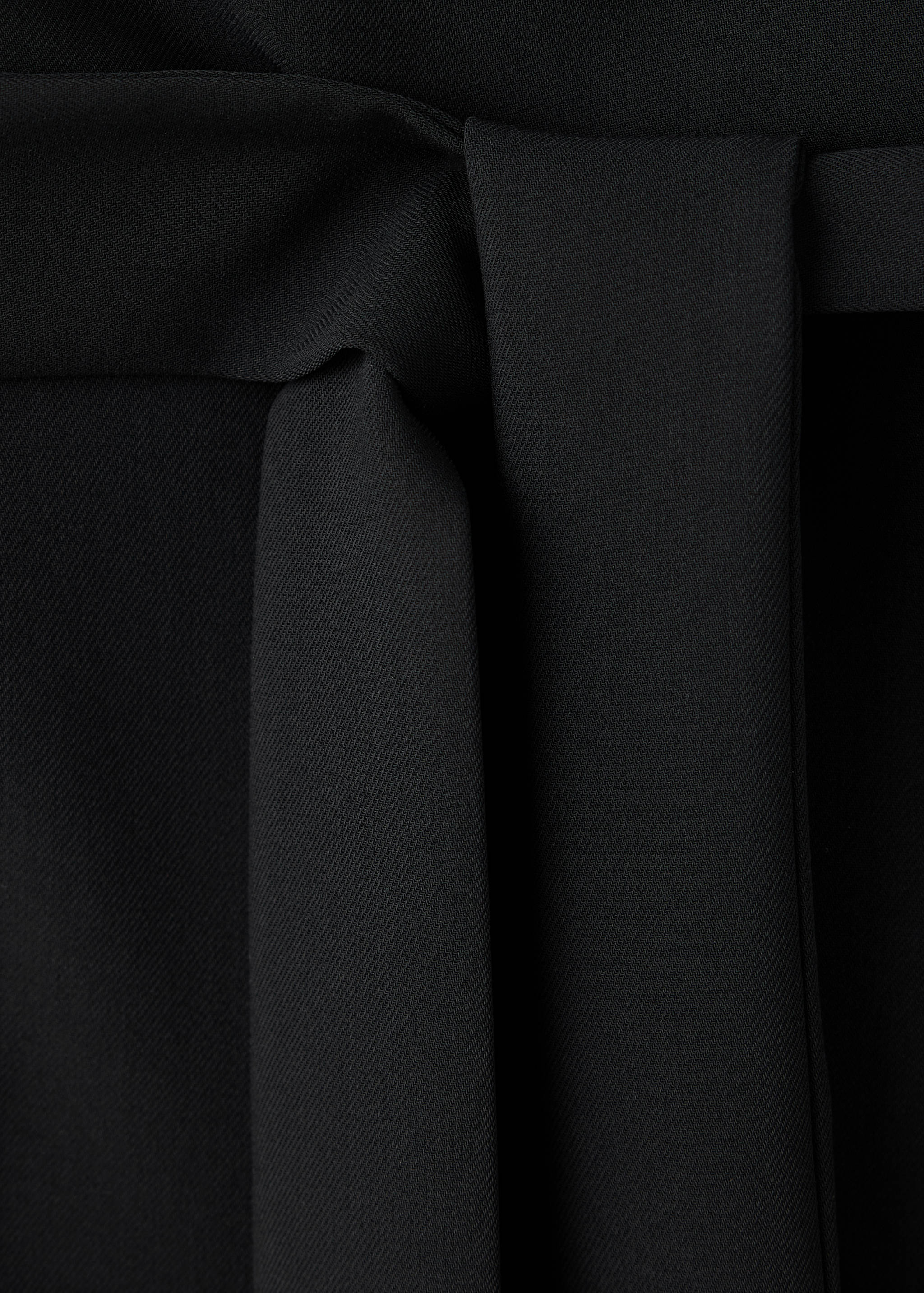 Close-up of a black jumpsuit waist with a matching self-tie belt.
