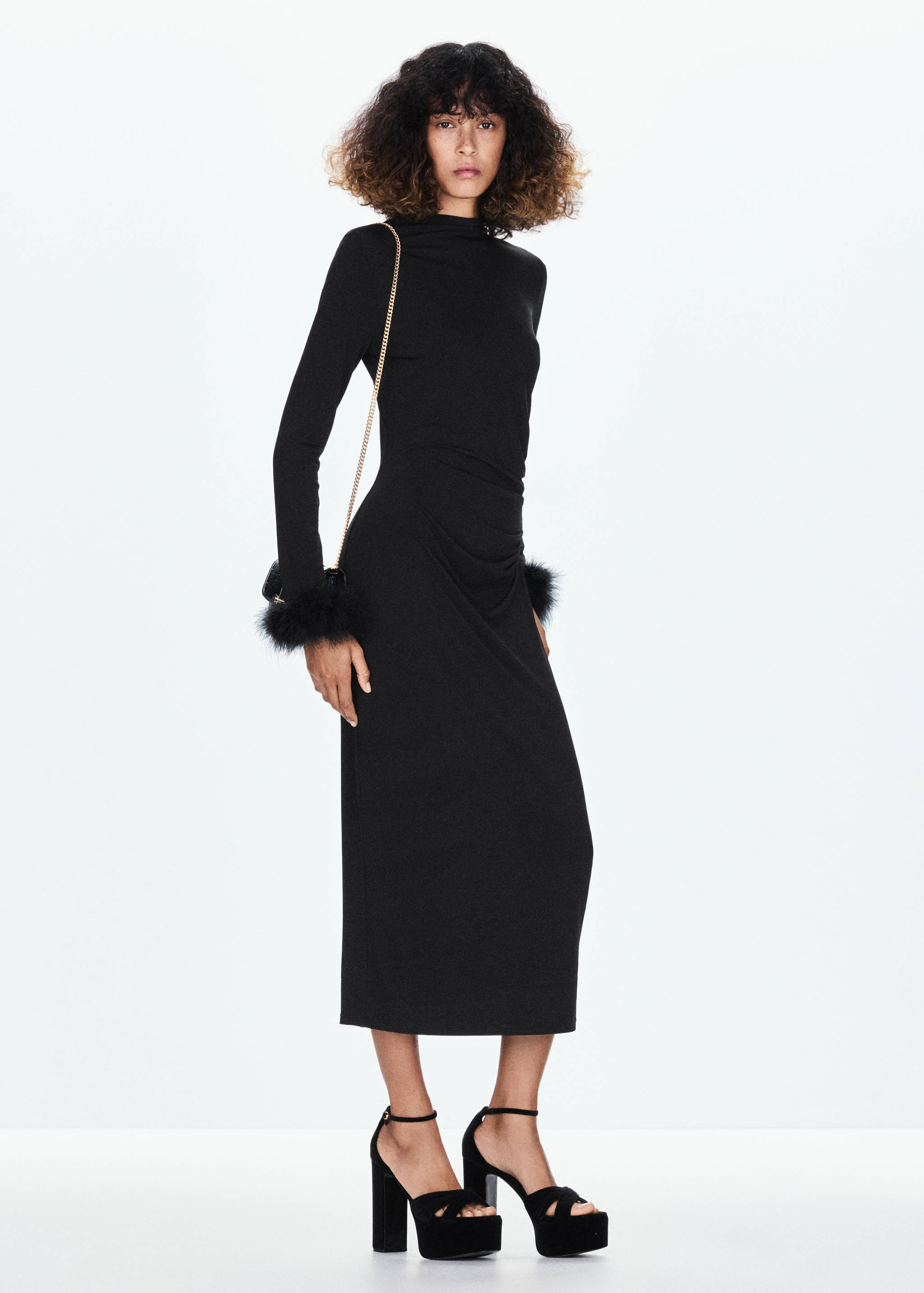 Black long-sleeved midi dress with high neck and faux-fur cuffs.