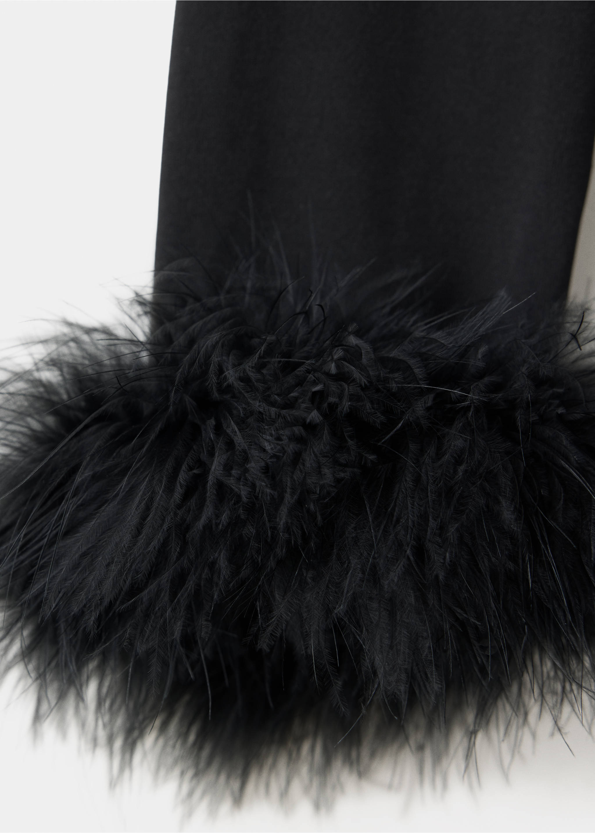 Close-up of a black dress sleeve with feather trim., Black. Ref: 37099122-00.