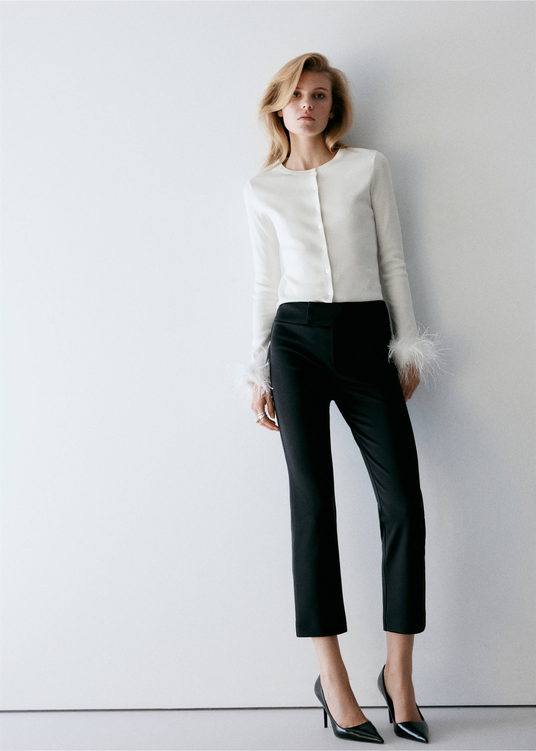 Cárdigan blanco de cuello redondo con puños de plumas y cierre de botones, combinado con pantalones negros., Crudo. Ref: 37099124-00.