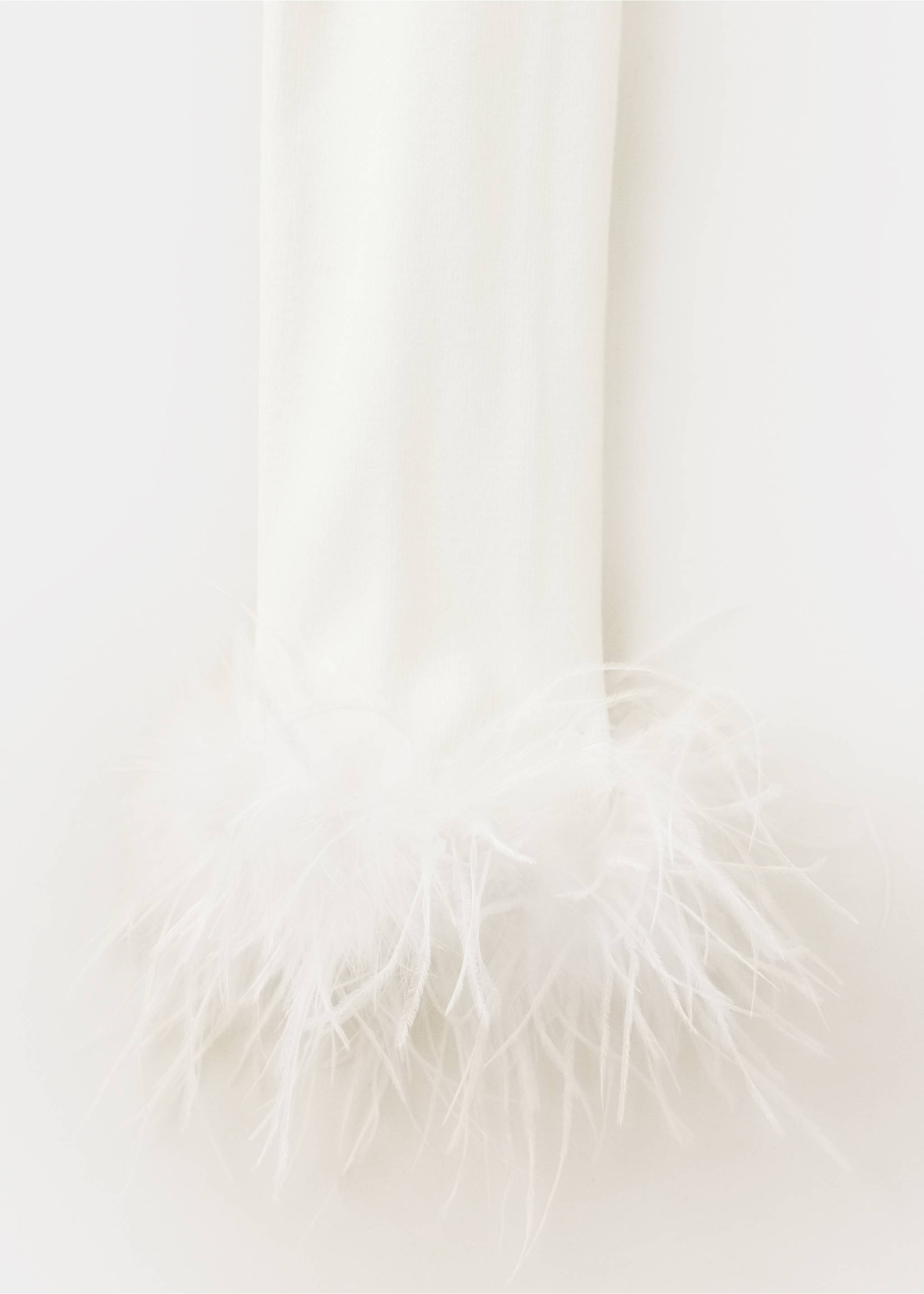 Primer plano de la manga de un cárdigan blanco con puño de plumas mullidas., Crudo. Ref: 37099124-00.