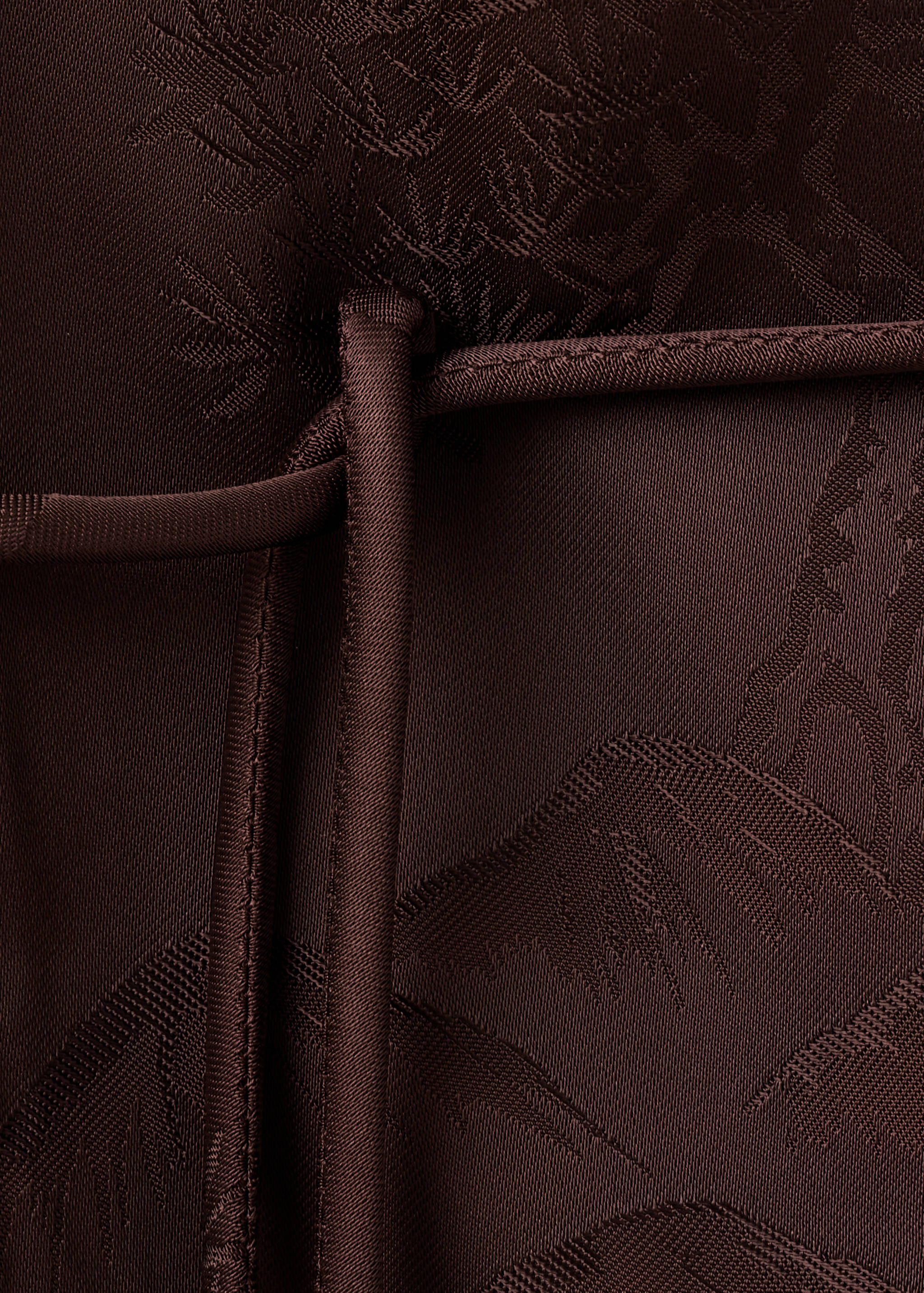 Close-up of the textured brown fabric detail of a blazer.