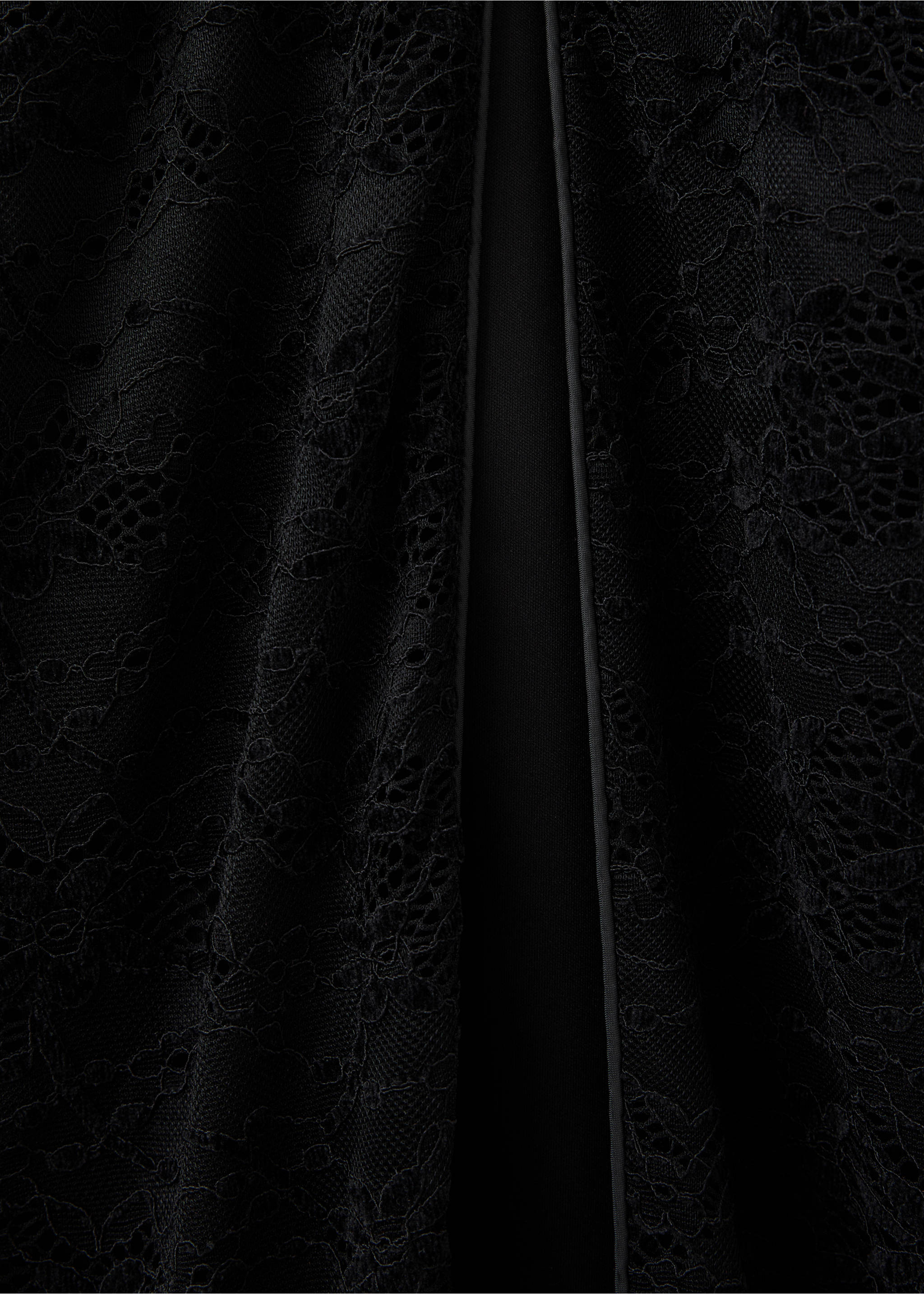 Close-up of black lace dress fabric with a vertical piped split., Black. Ref: 37099129-00.
