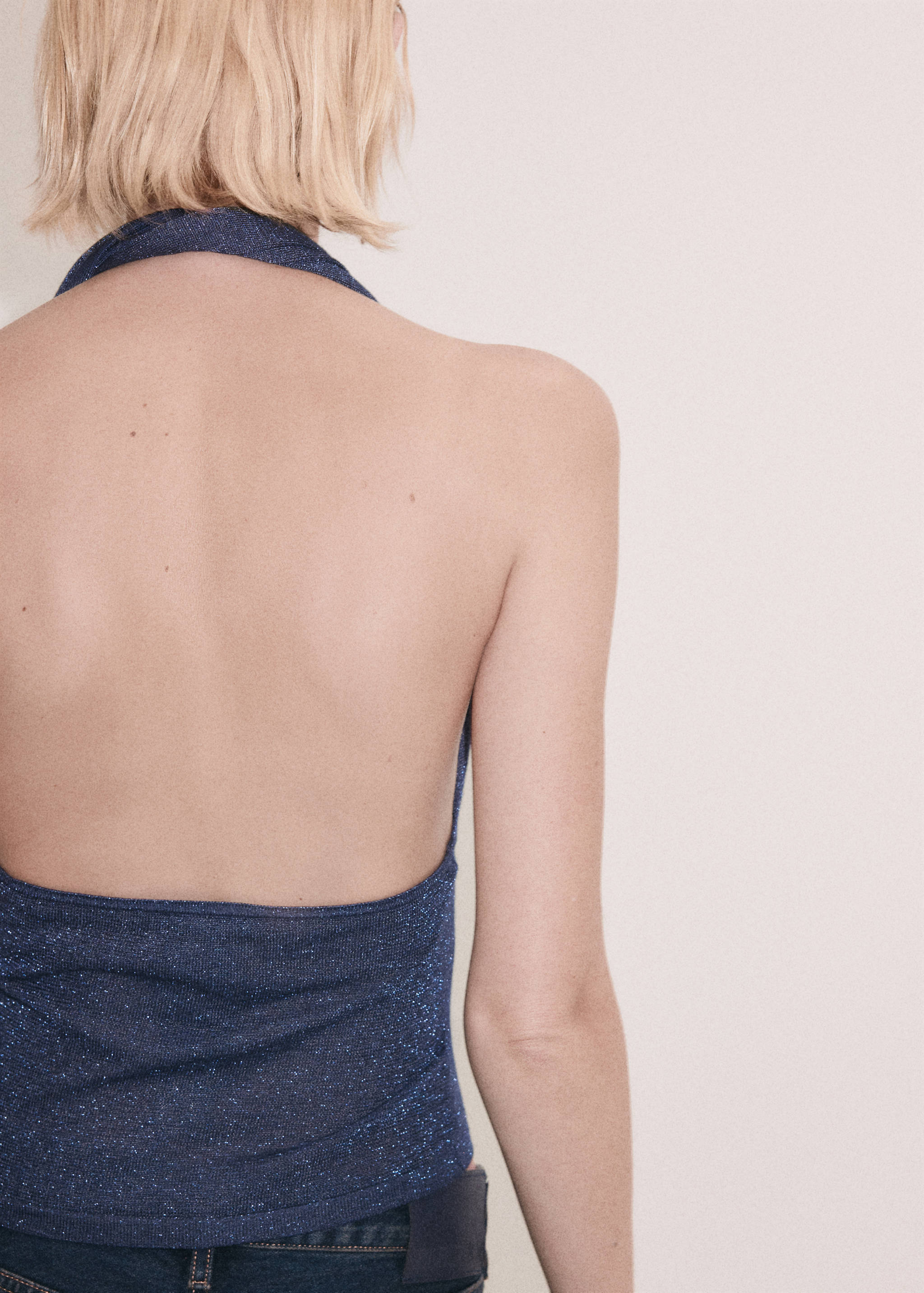 Dark blue sparkly halter top with an open back, back view.