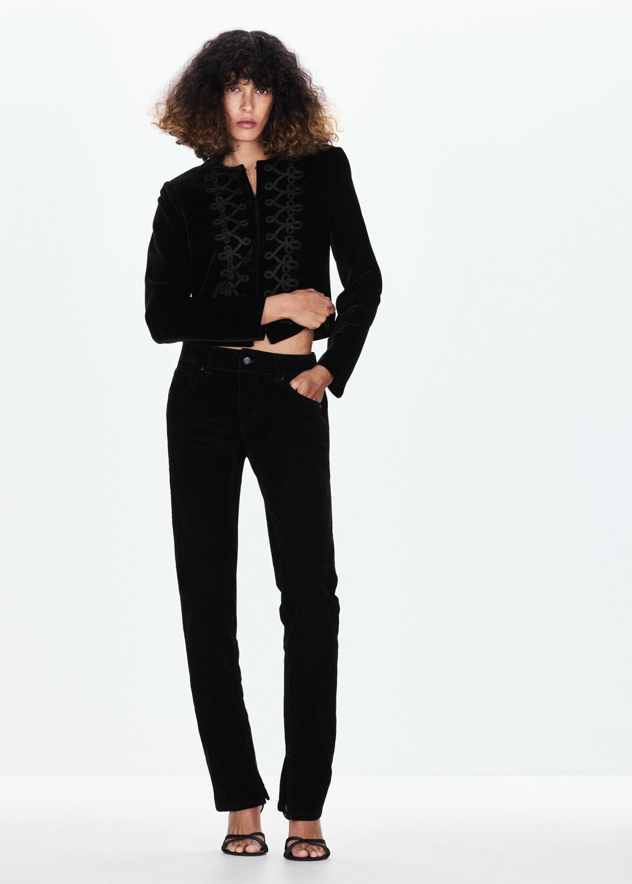 Black velvet jacket with braided cord embroidery and collarless neckline.