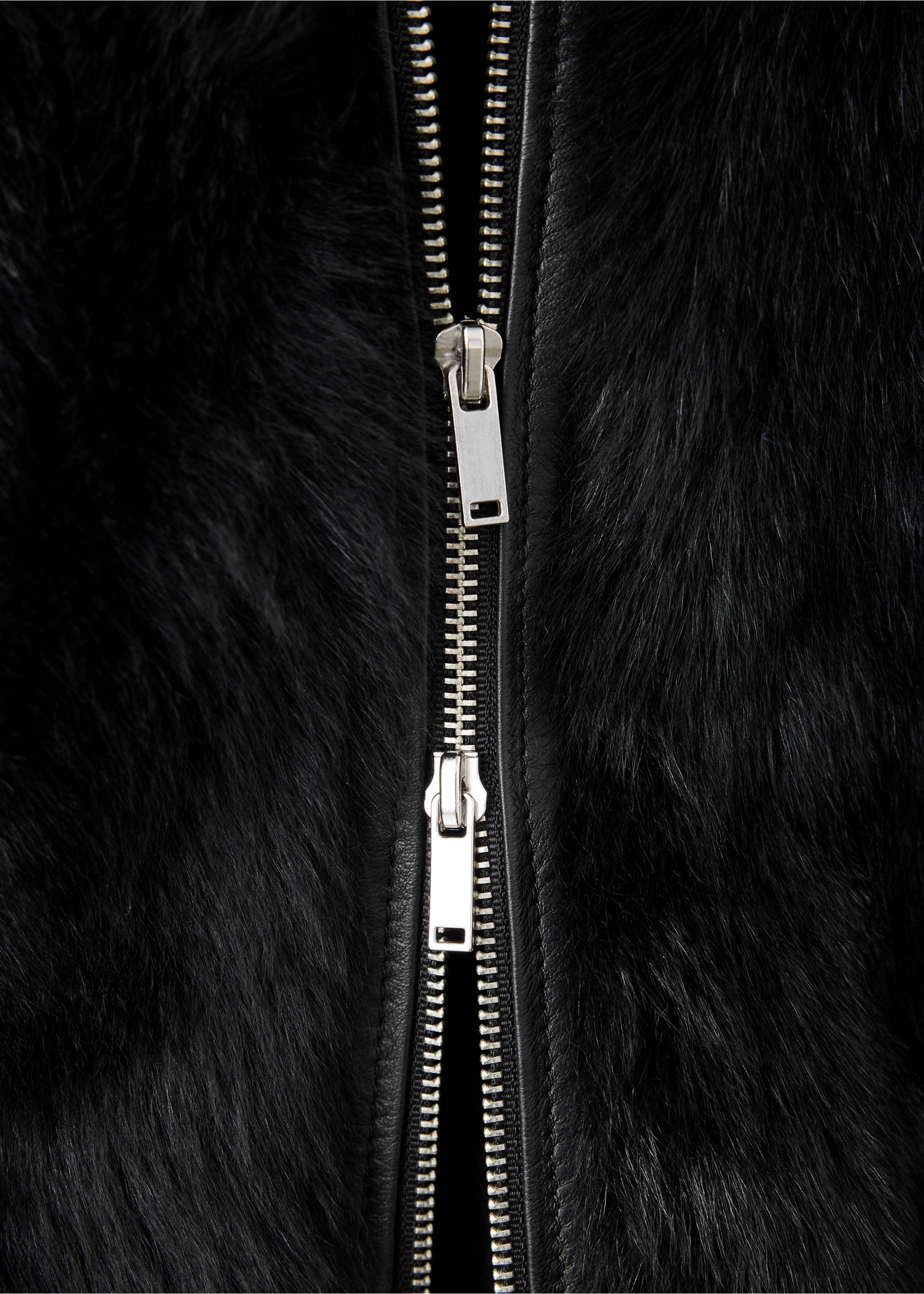 Black faux-fur jacket detail showing a silver metal zip closure., Black. Ref: 37099136-00.