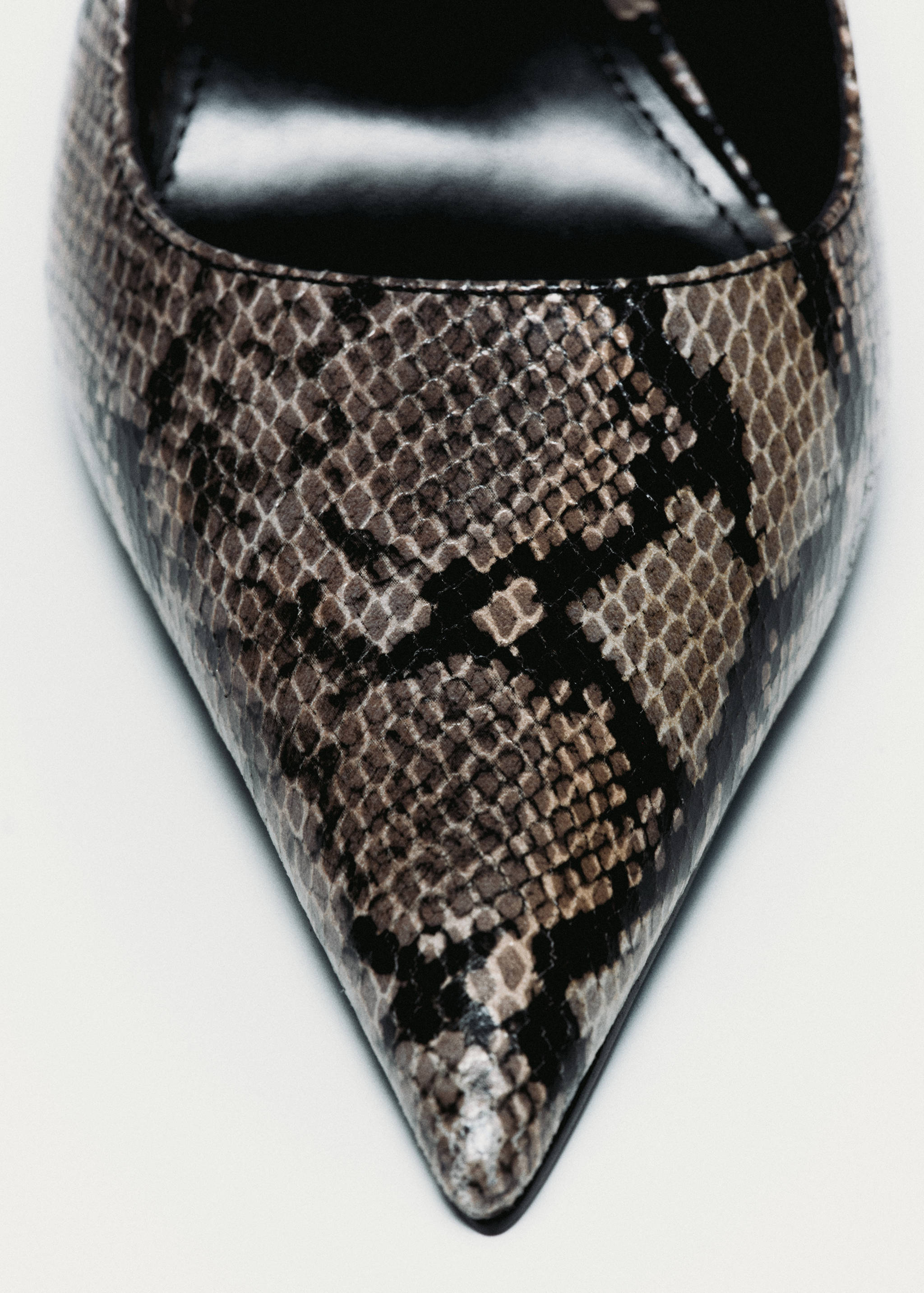 Close-up of a pointed-toe shoe with a brown and black animal print.