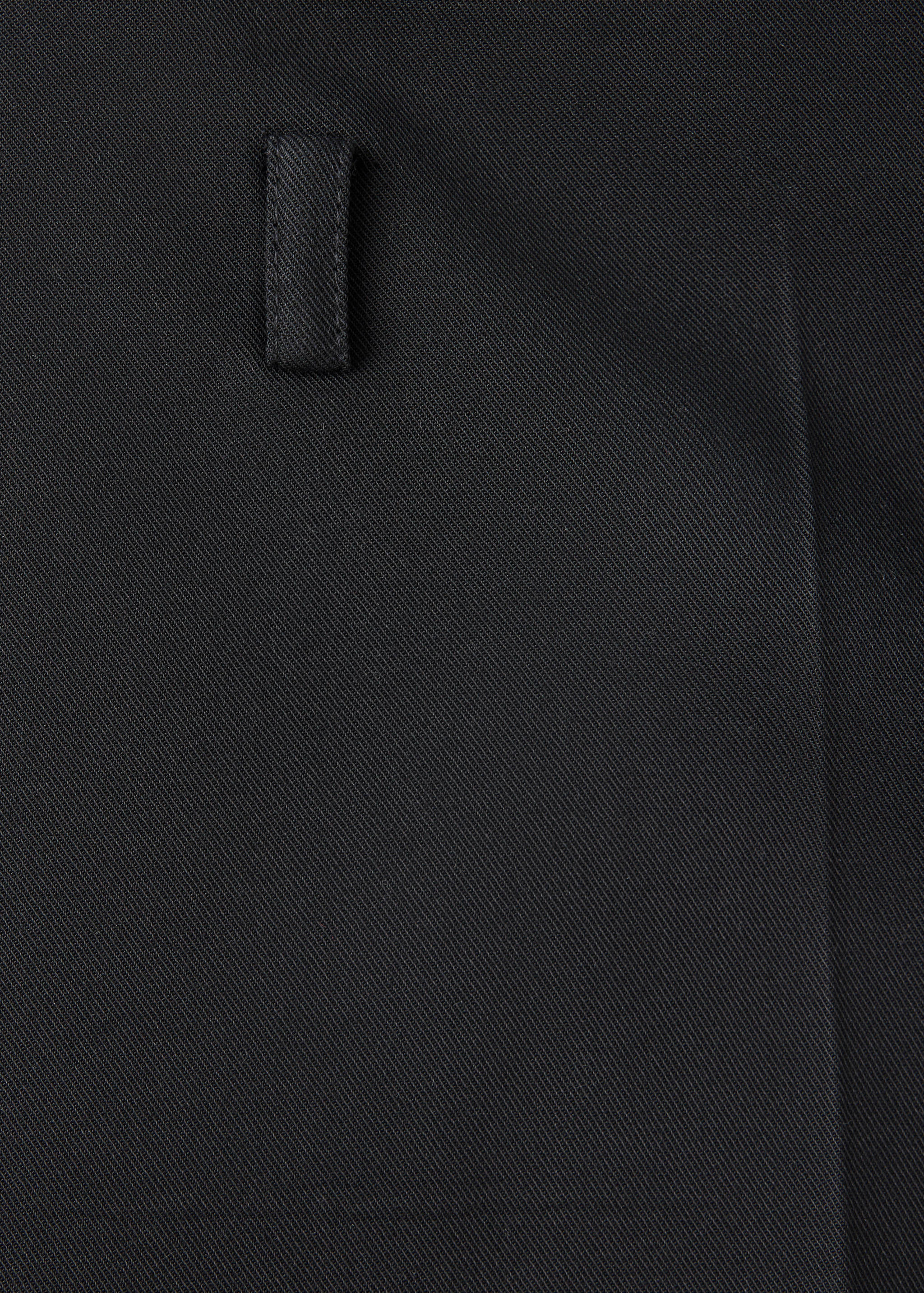 Close-up of black shorts showing the fabric texture and belt loop.