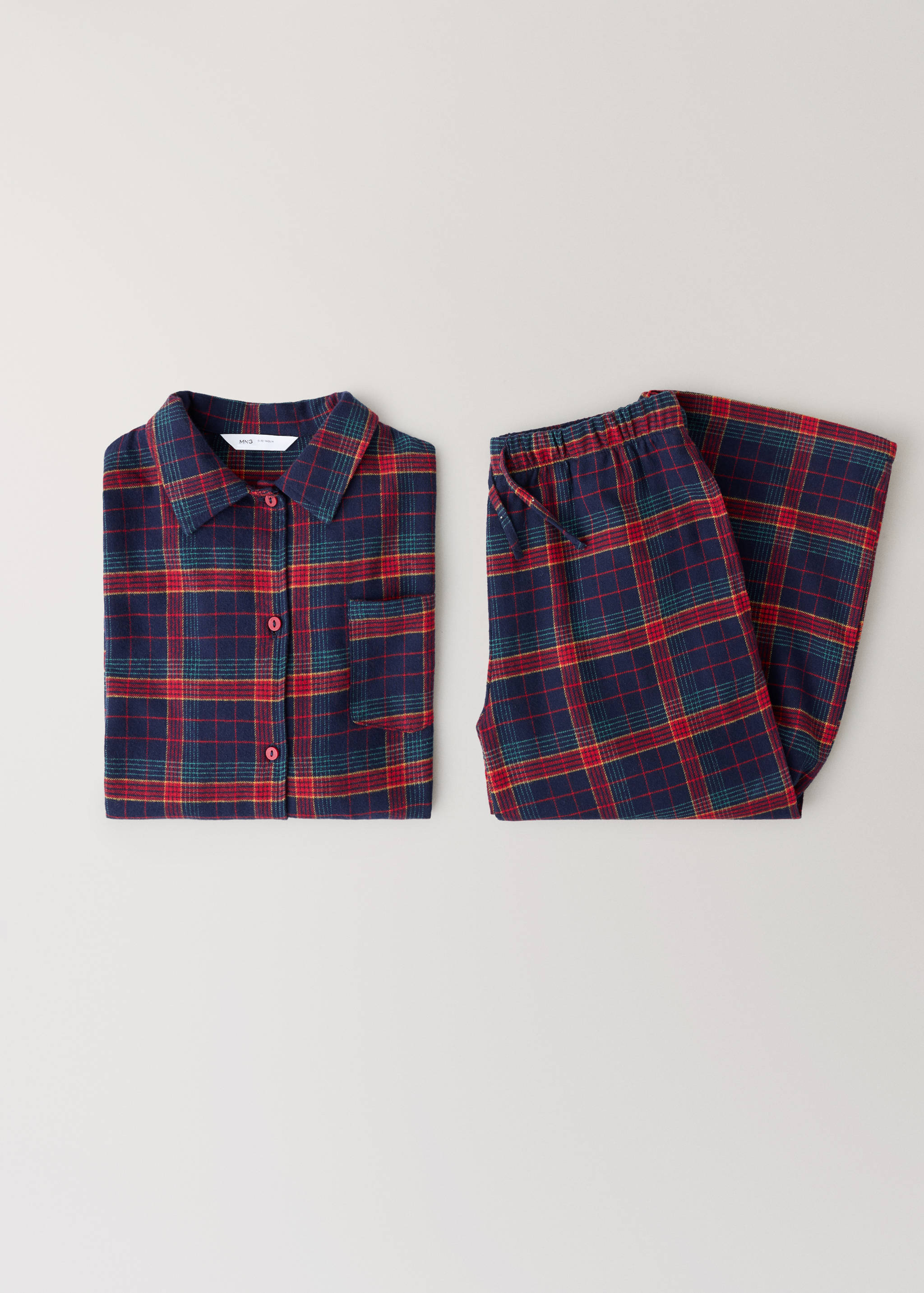 Folded navy red tartan pyjama set with shirt and trousers.