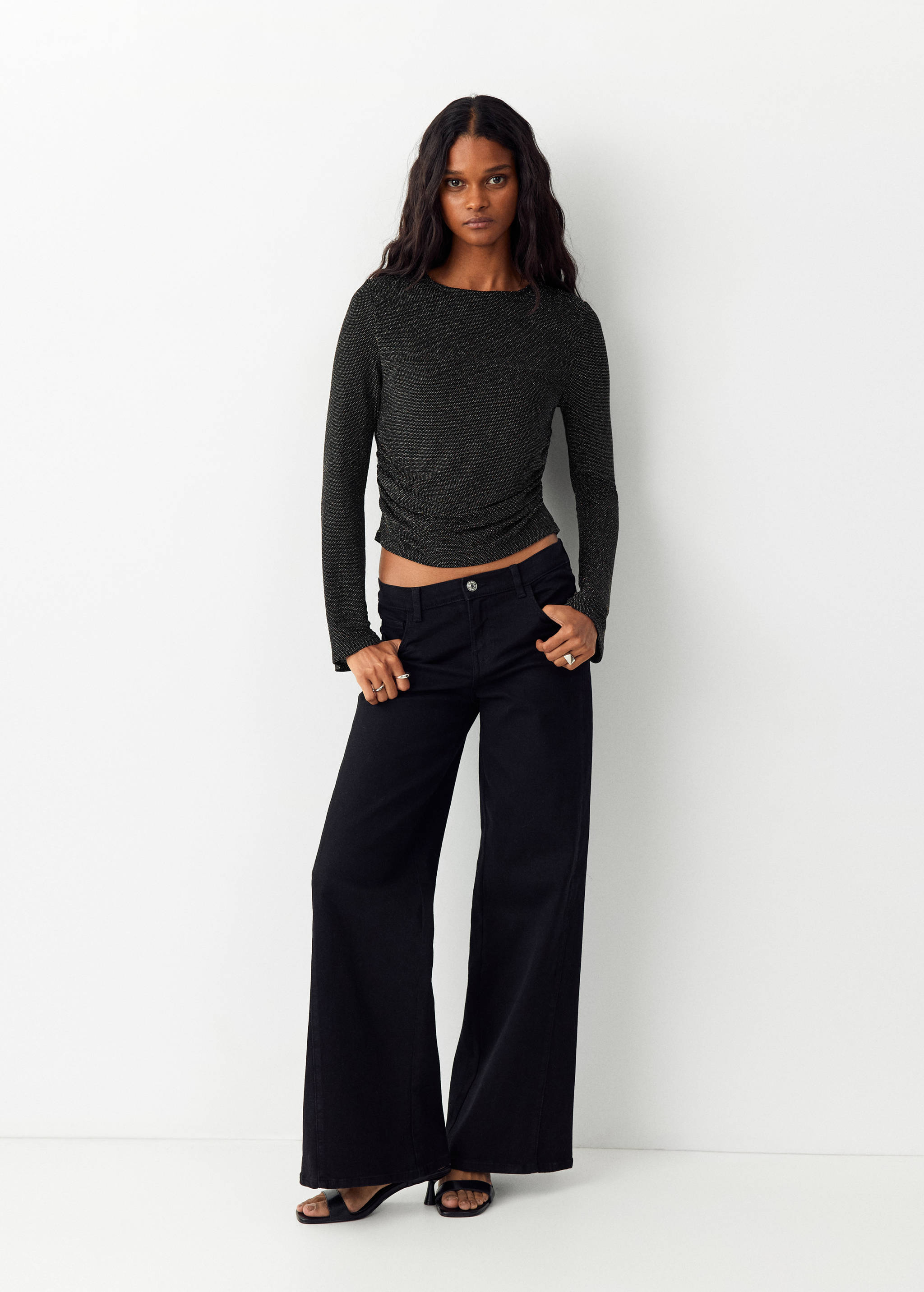 Dark grey metallic long-sleeve t-shirt with ruched side detail, worn with black trousers.