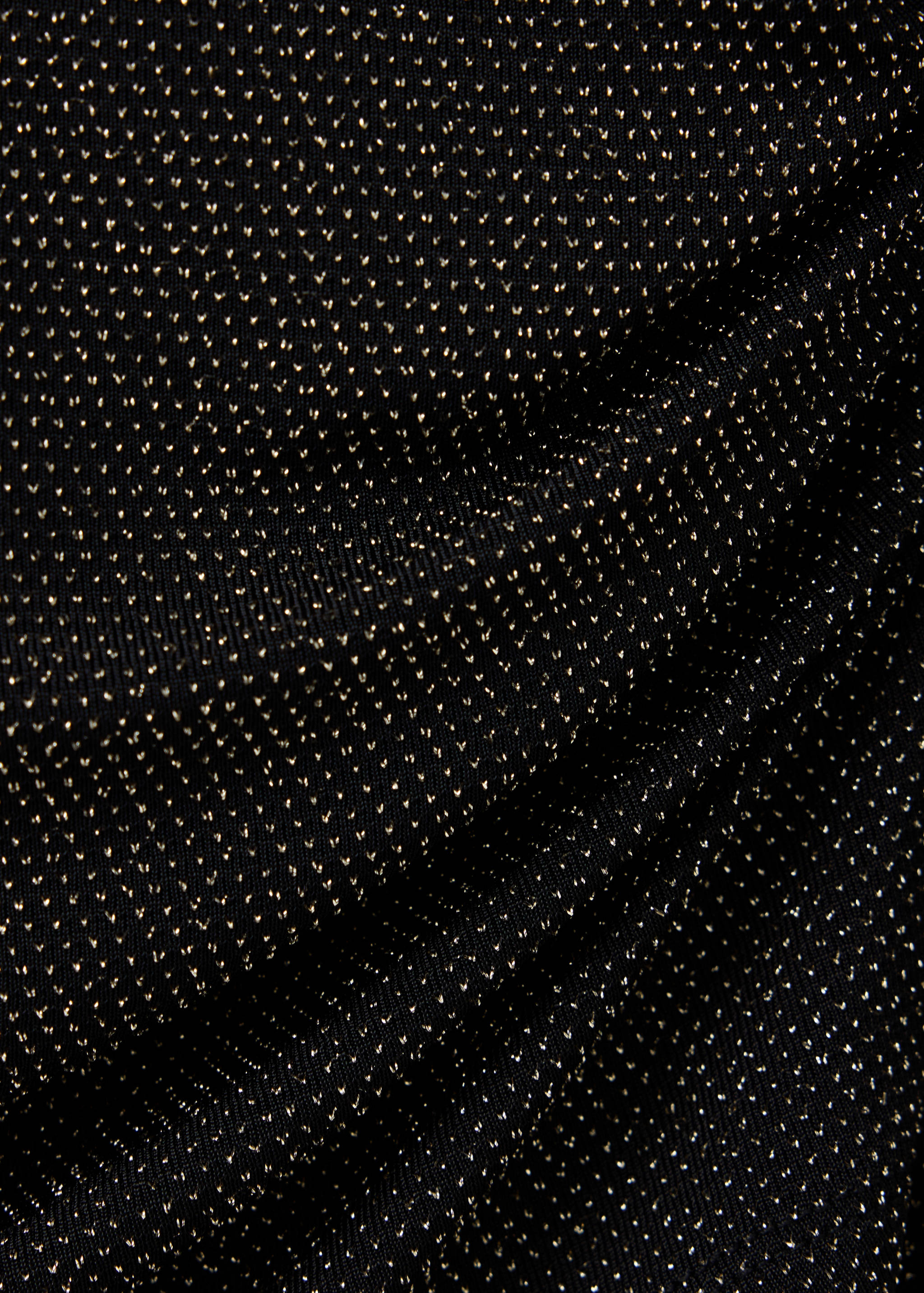 Close-up of a black t-shirt with a metallic gold dot pattern.
