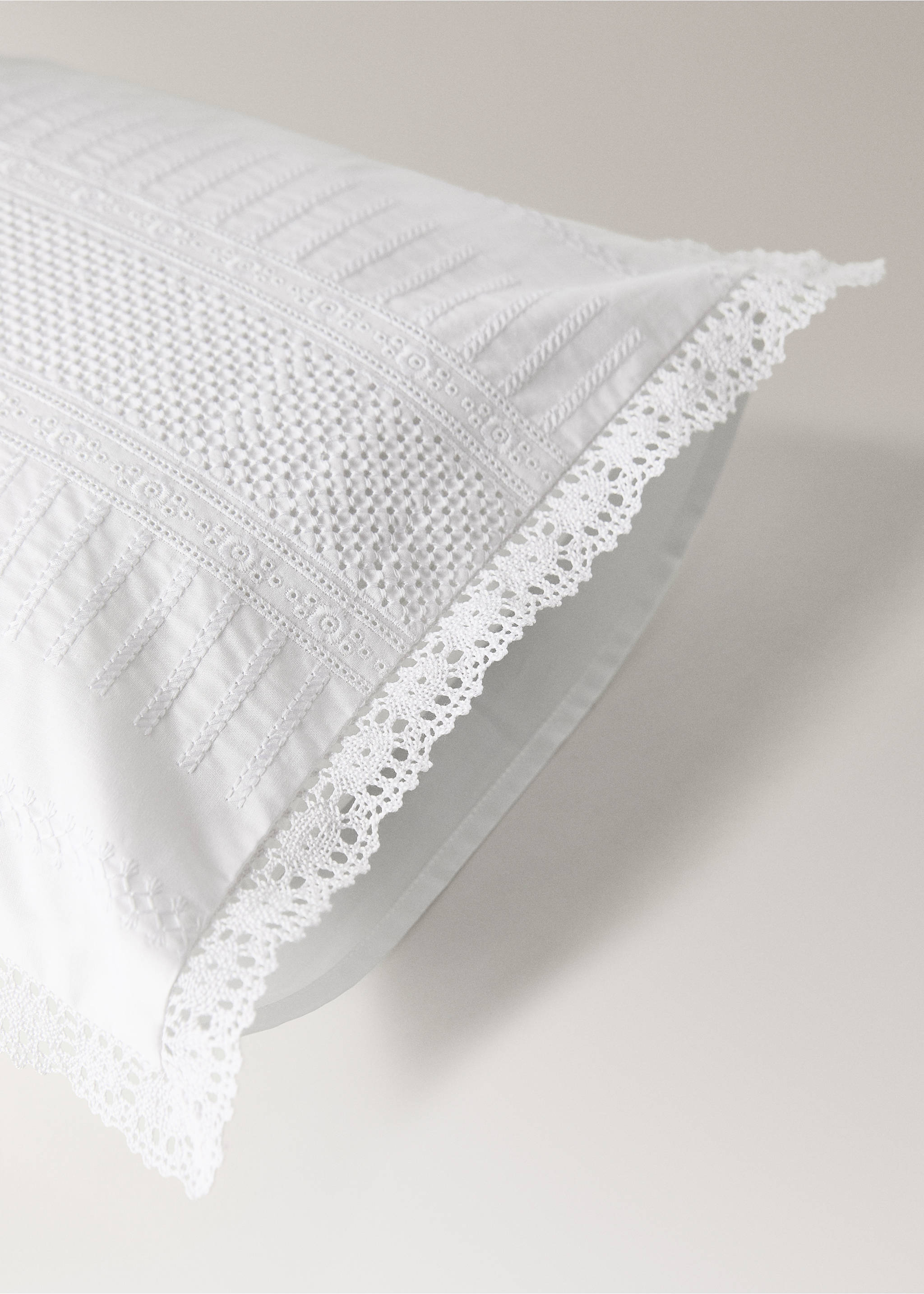 White cushion cover with intricate embroidered panels and lace trim., White. Ref: 37141588-00.