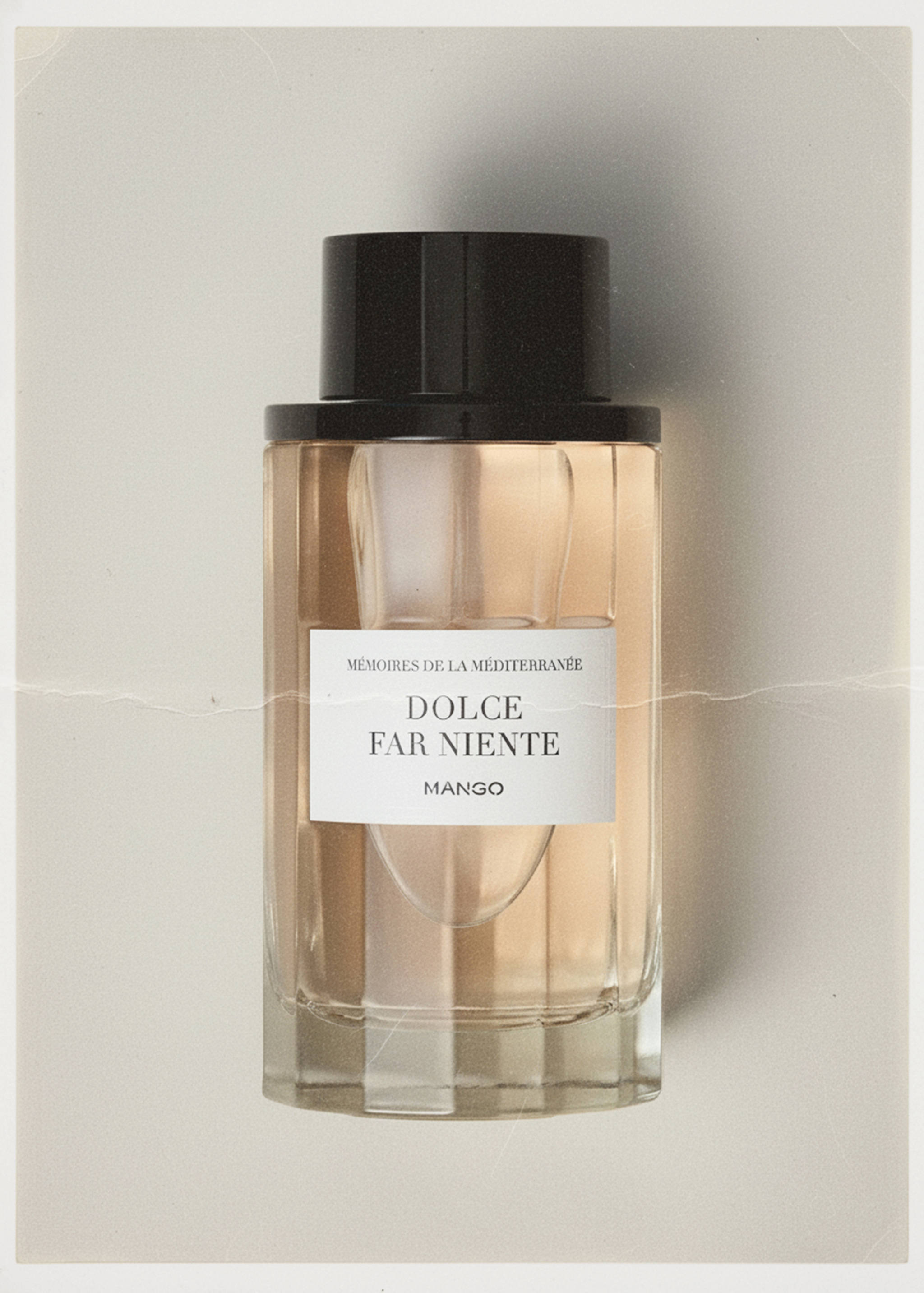 Dolce Far Niente glass perfume bottle with black cap and white label.