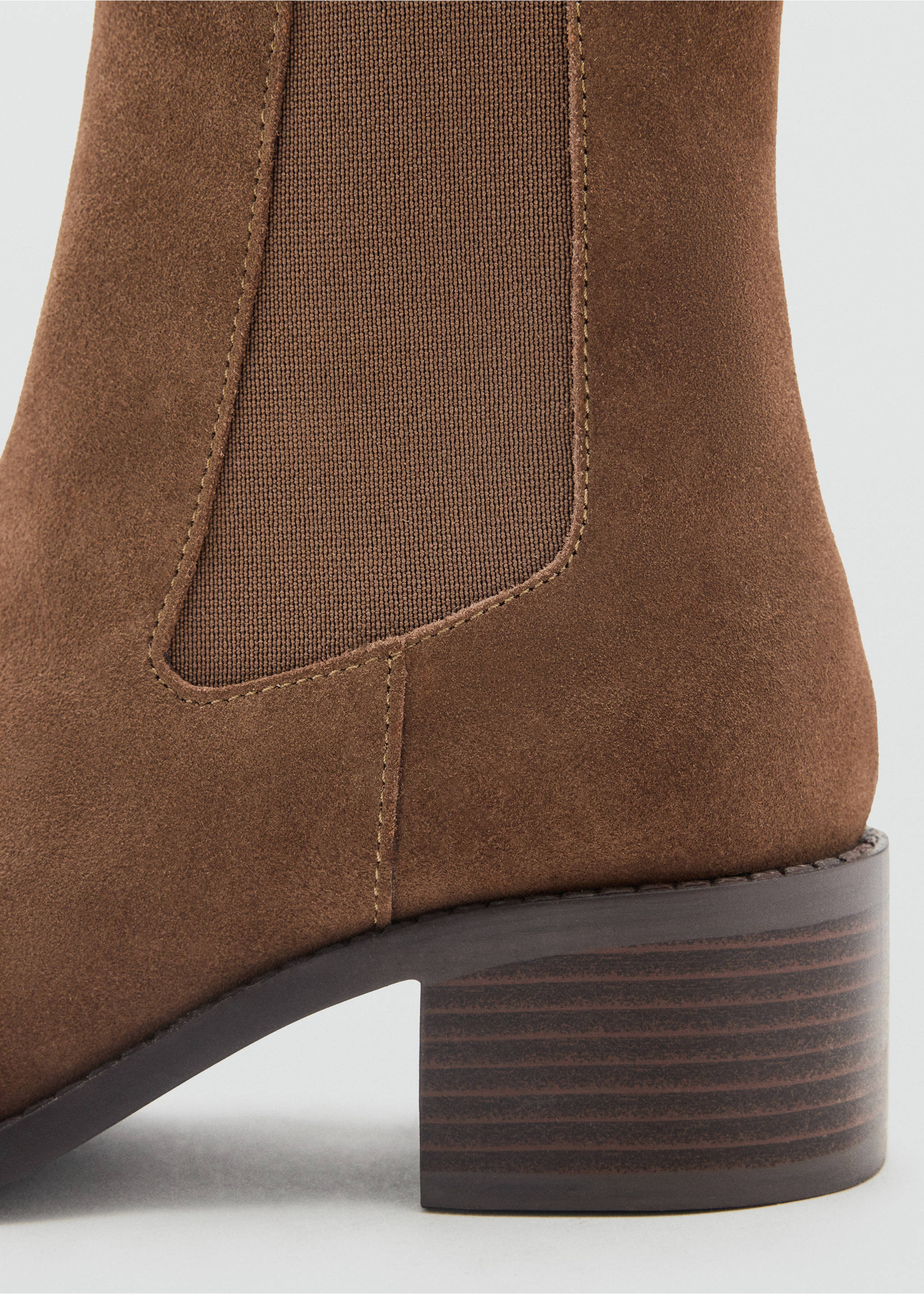 Close-up of a brown ankle boot featuring a low block heel and elastic side panel., Chocolate. Ref: 37945155-00.