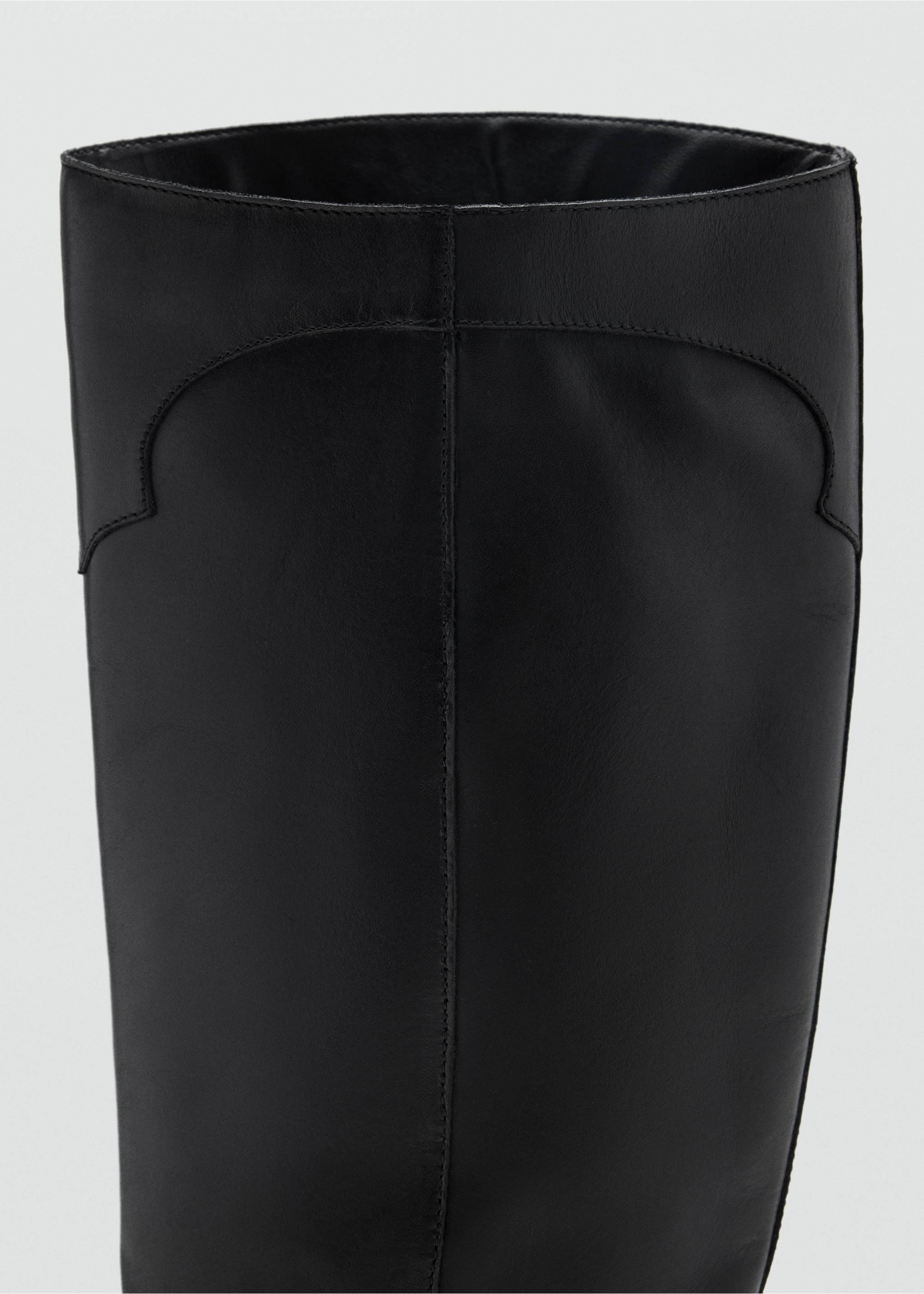 Close-up of the upper shaft of a black boot with decorative stitching., Black. Ref: 37966723-00.