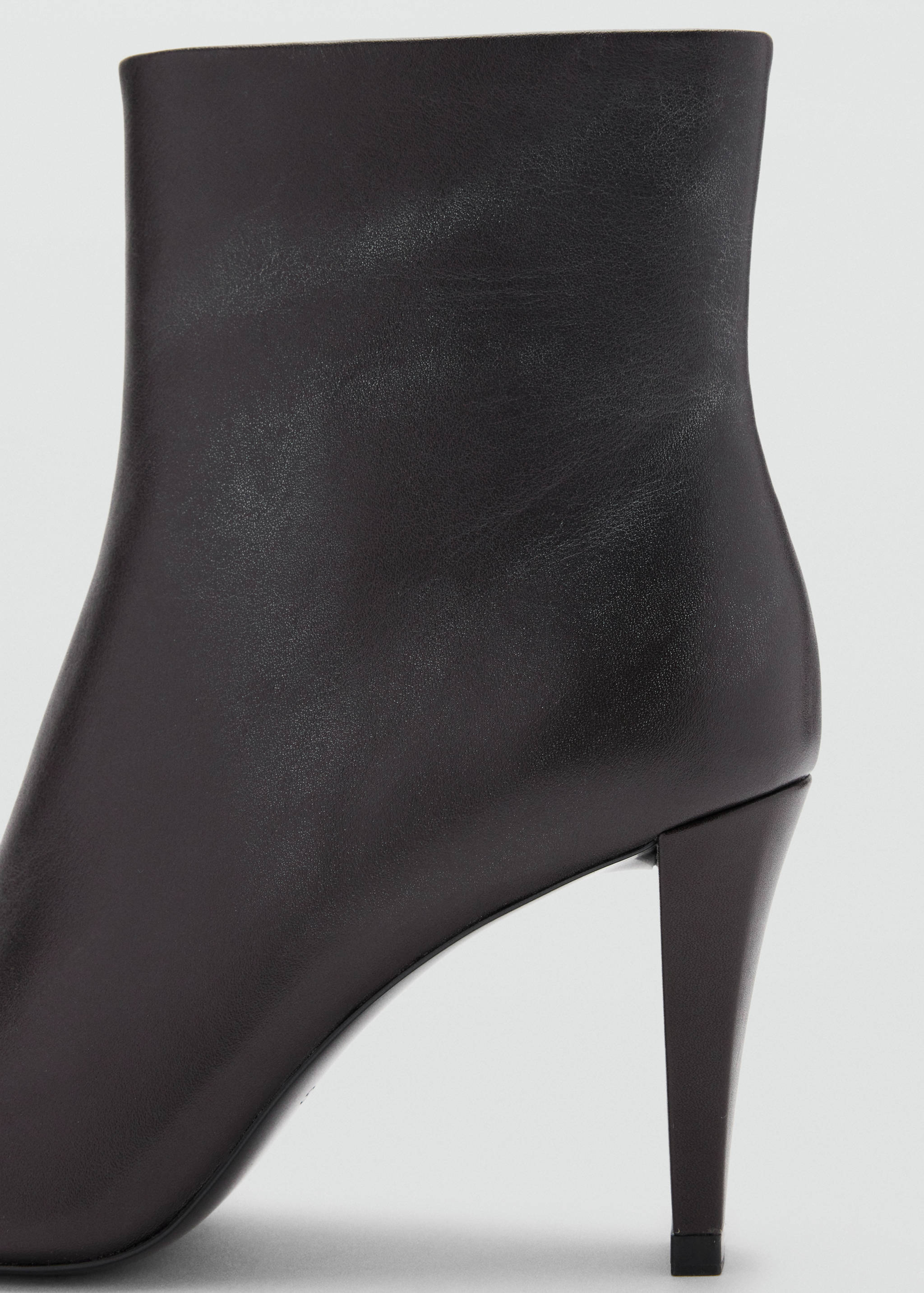 Close-up of a black stiletto ankle boot with a smooth finish.