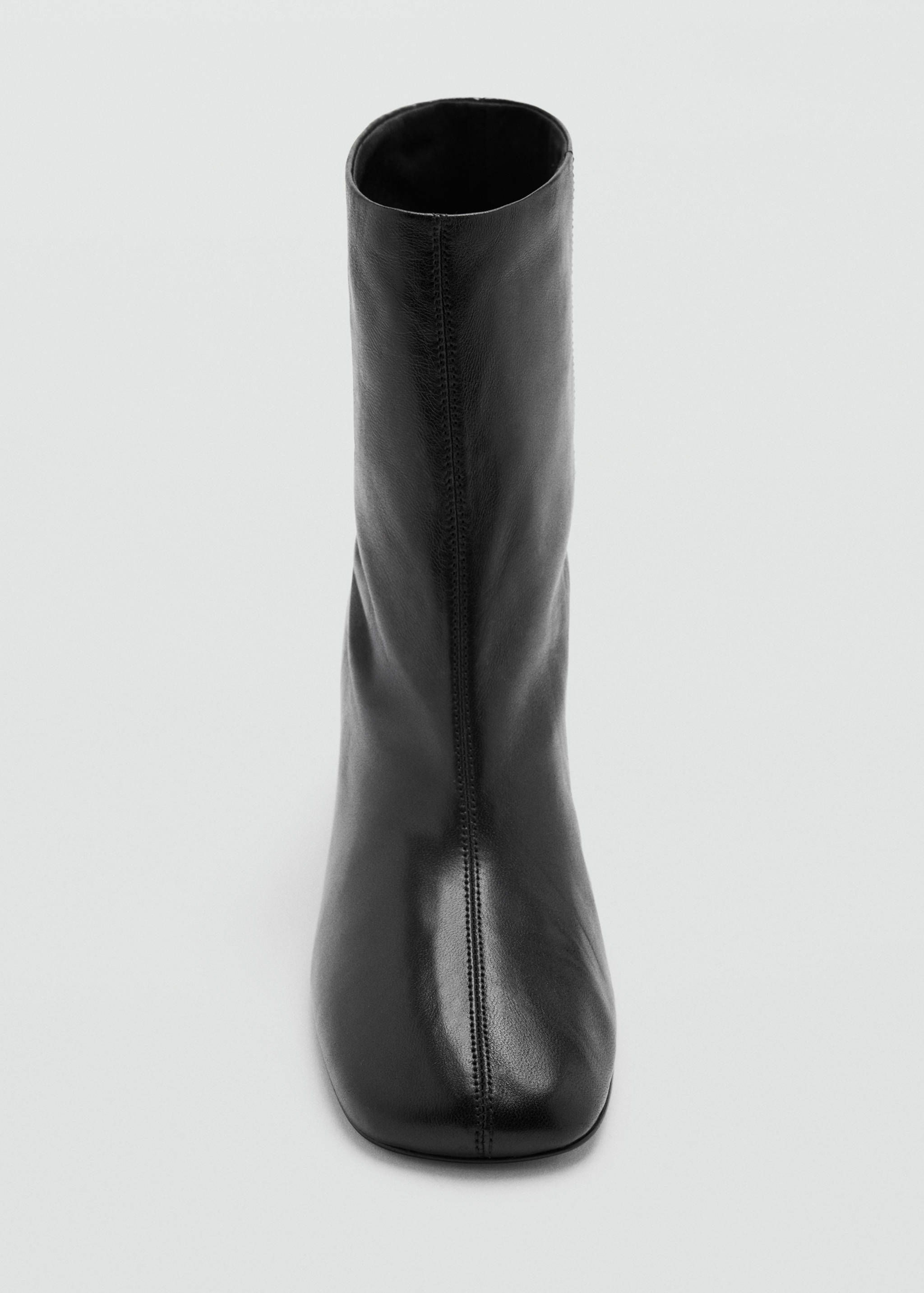Close-up of a black leather ankle boot with a rounded square toe and central vertical seam.