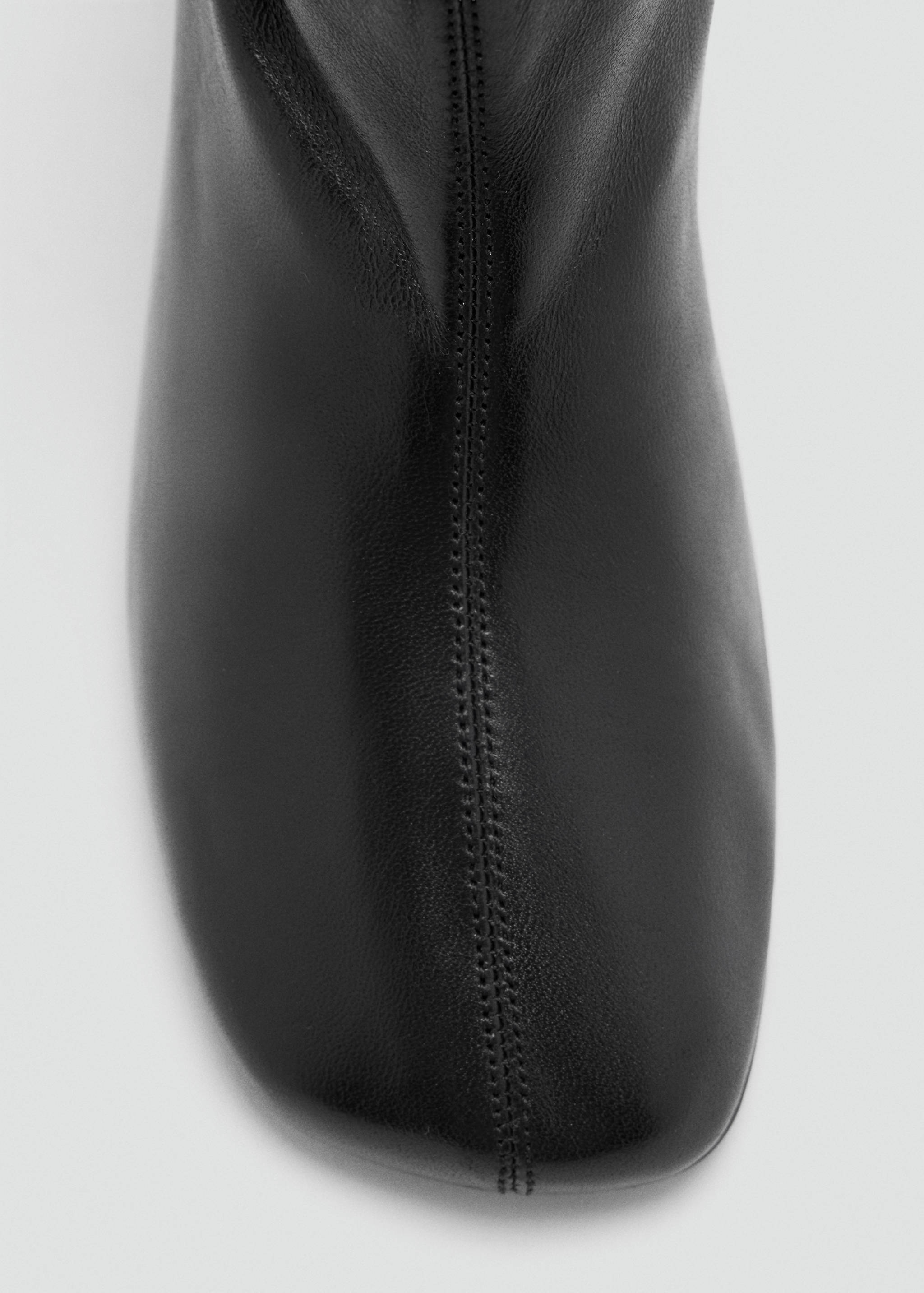 Close-up of a black leather ankle boot with a square toe.