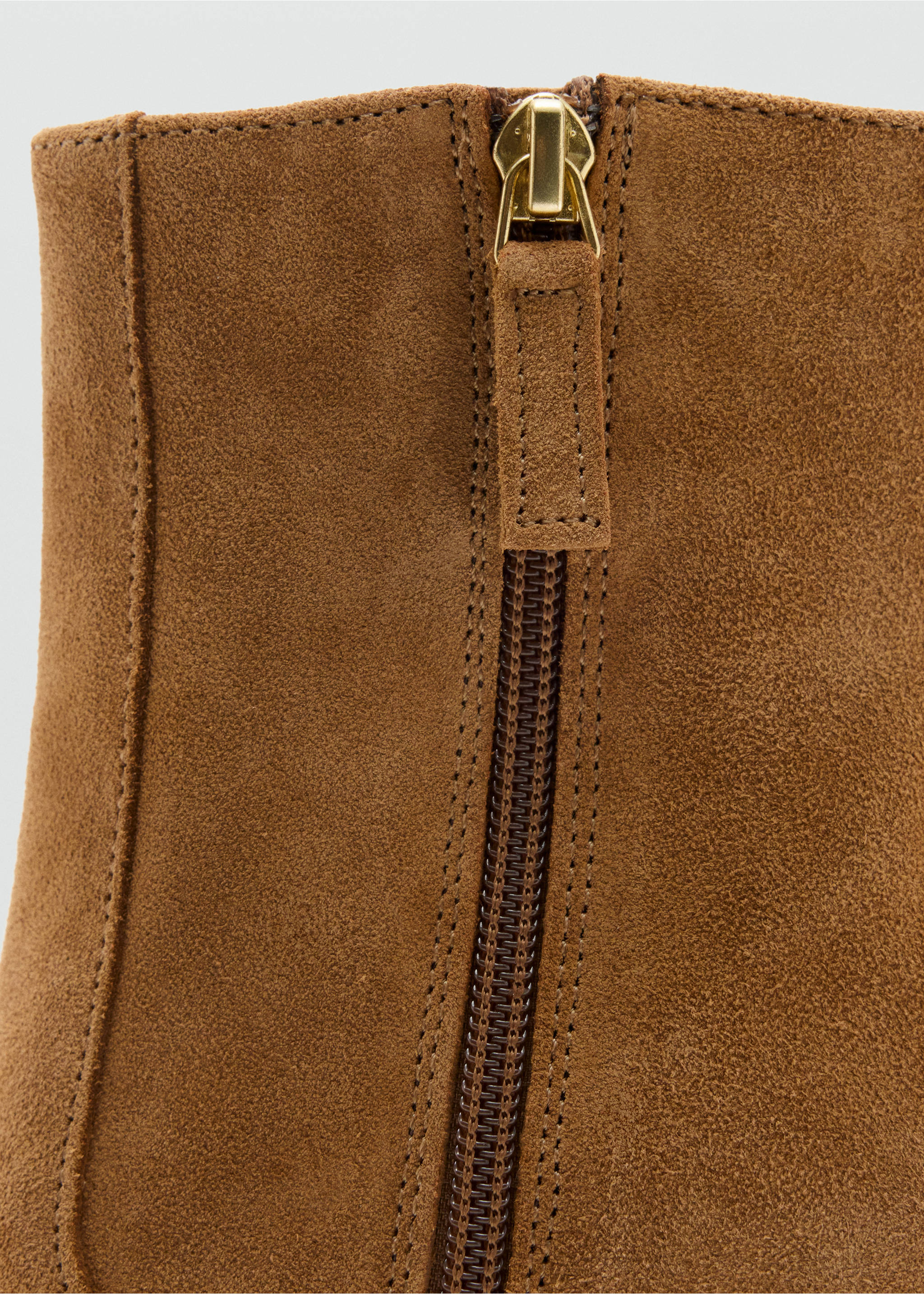 Close-up of the gold-toned zipper detail on brown suede ankle boots., Tobacco Brown. Ref: 47001350-00.
