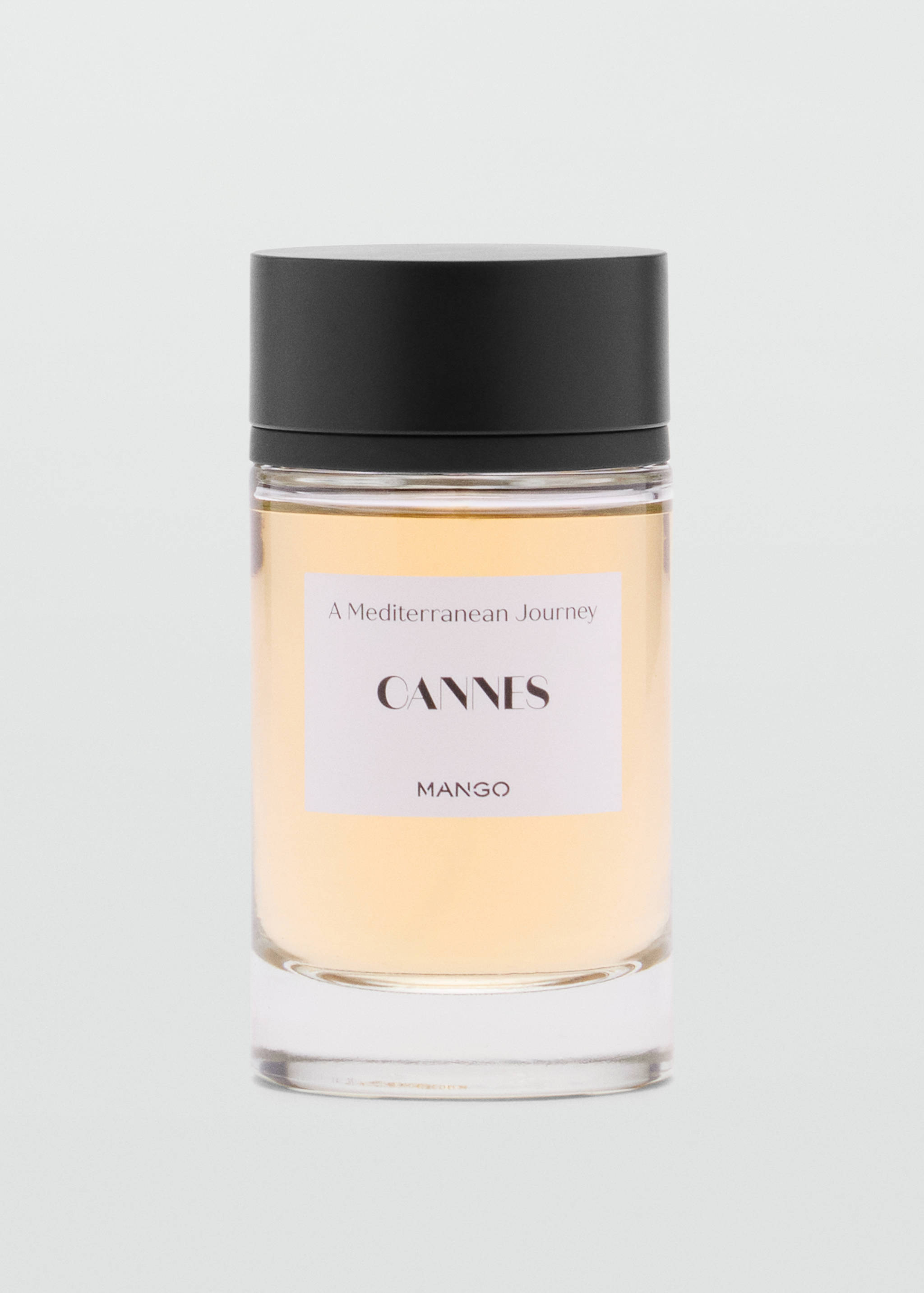 Cannes perfume bottle with amber liquid and black cap.