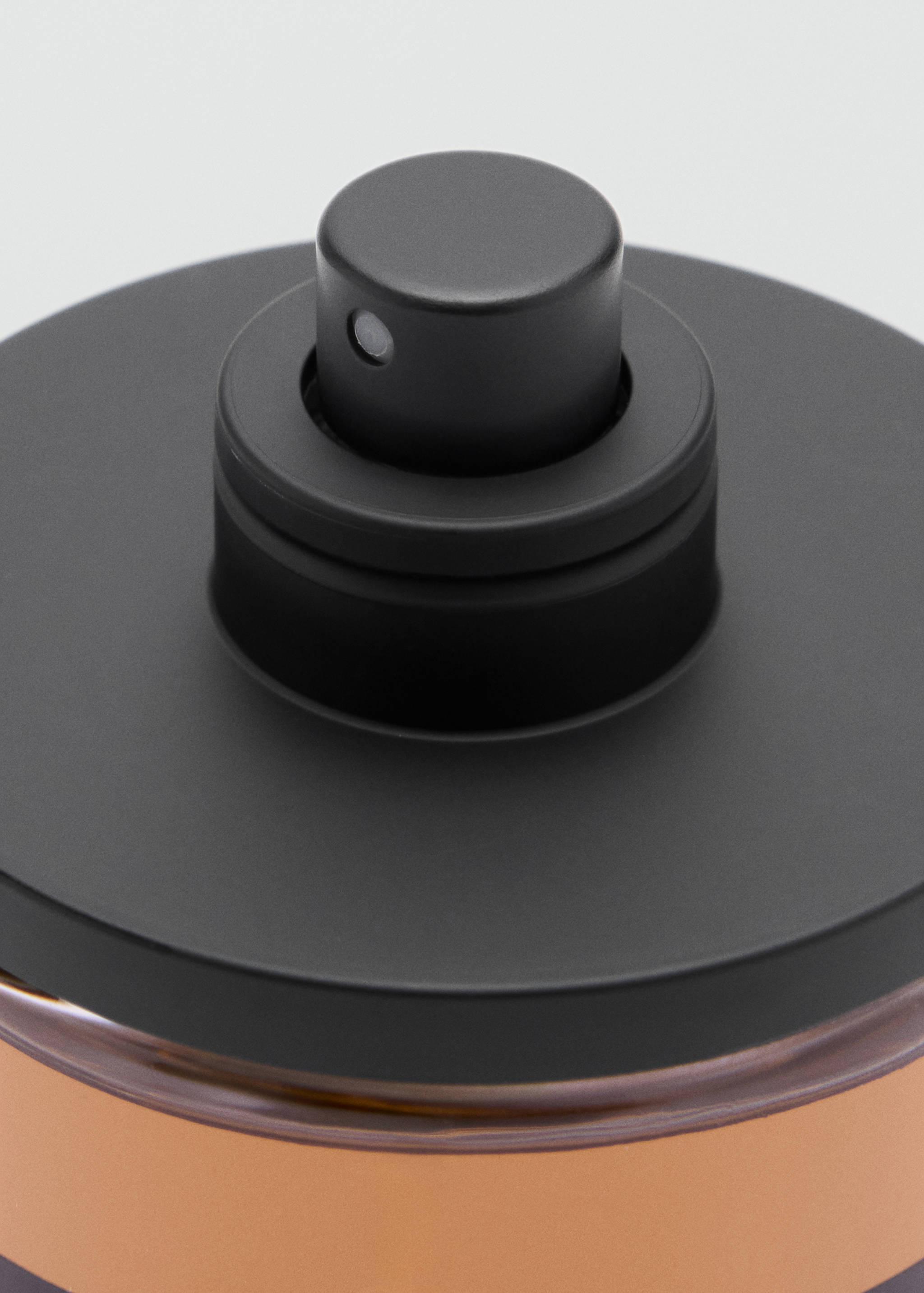 Close-up of the black spray nozzle on a perfume bottle.