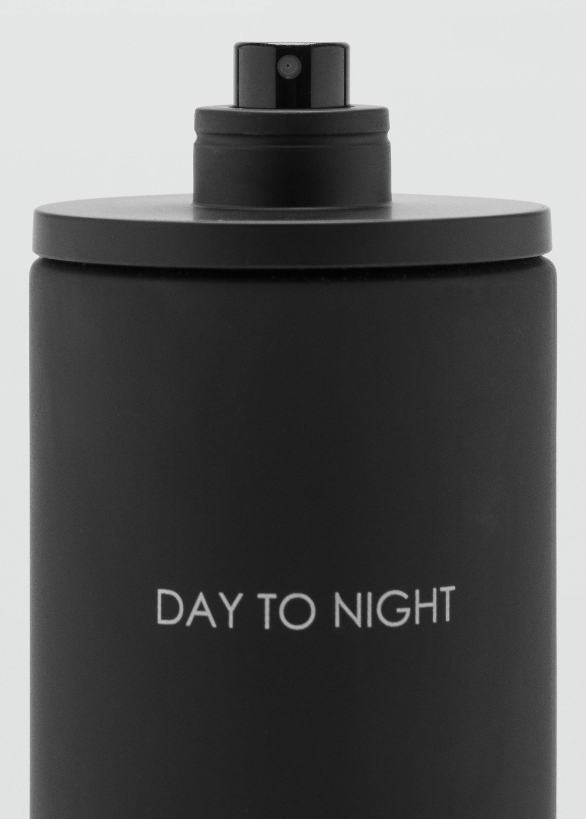 Close-up of a matte black perfume bottle with white text.