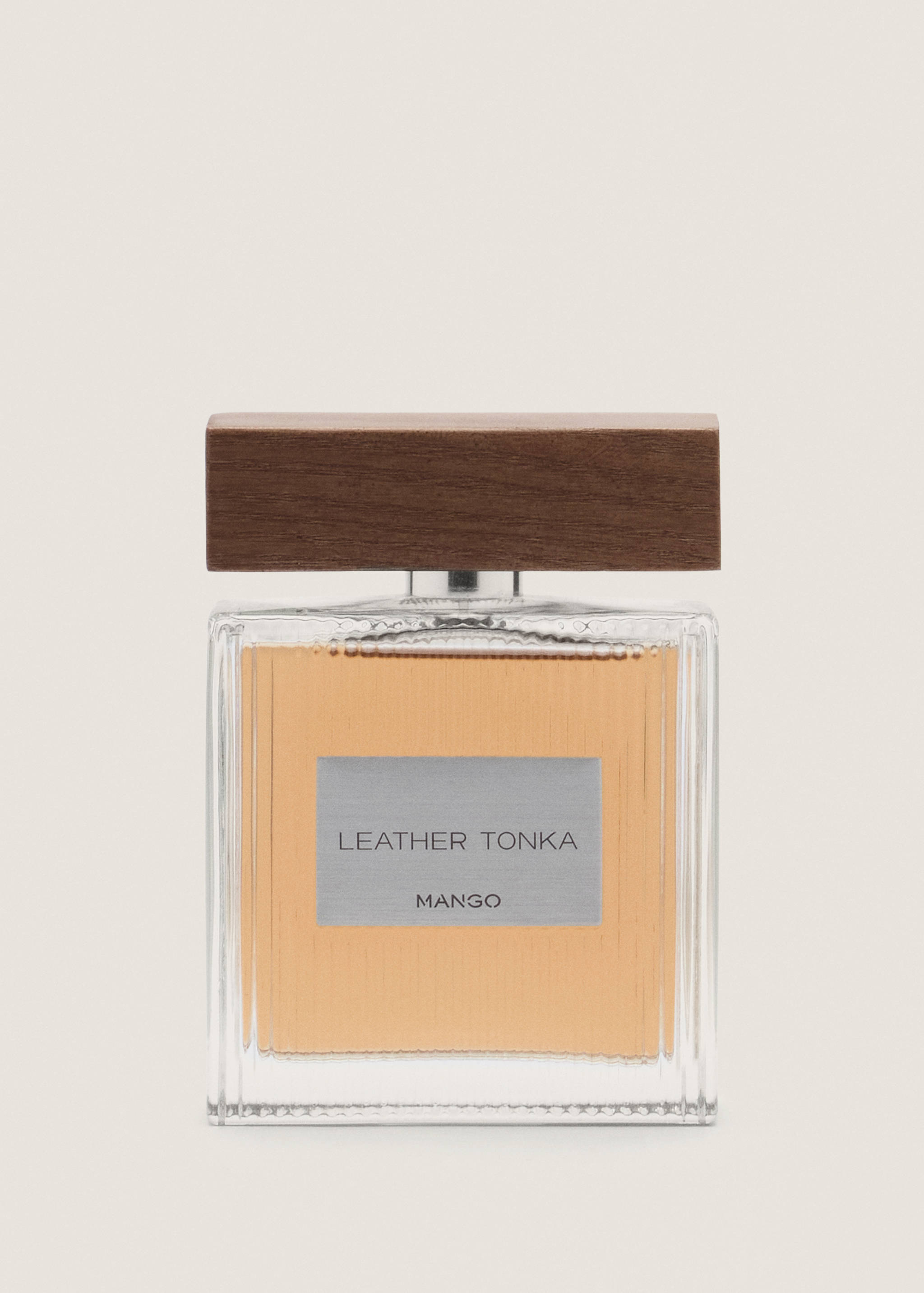 Perfume bottle with amber liquid, silver label, and dark wooden cap.