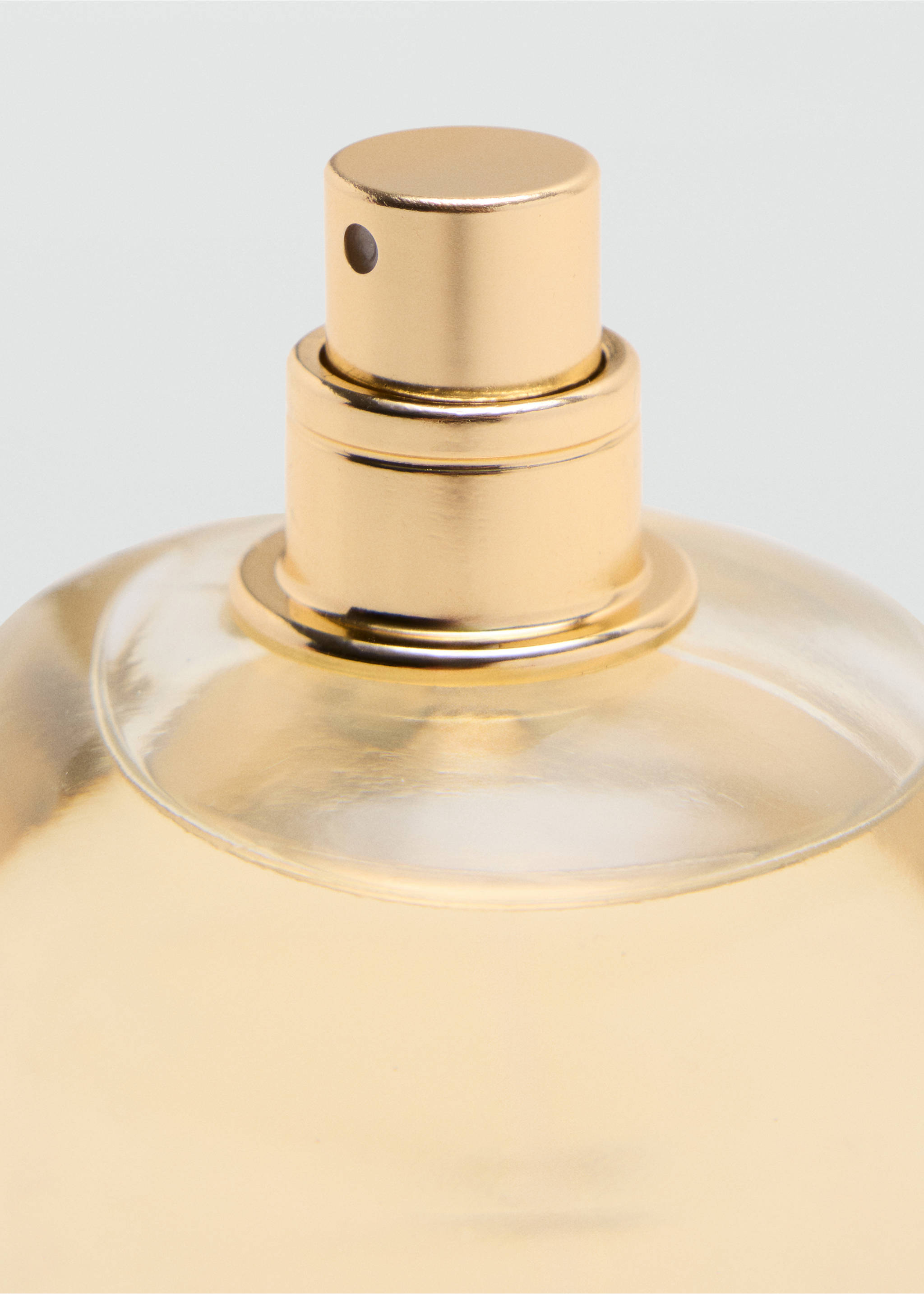 Close-up of a perfume bottle's metallic gold spray nozzle., Mink Grey. Ref: 47001456-00.