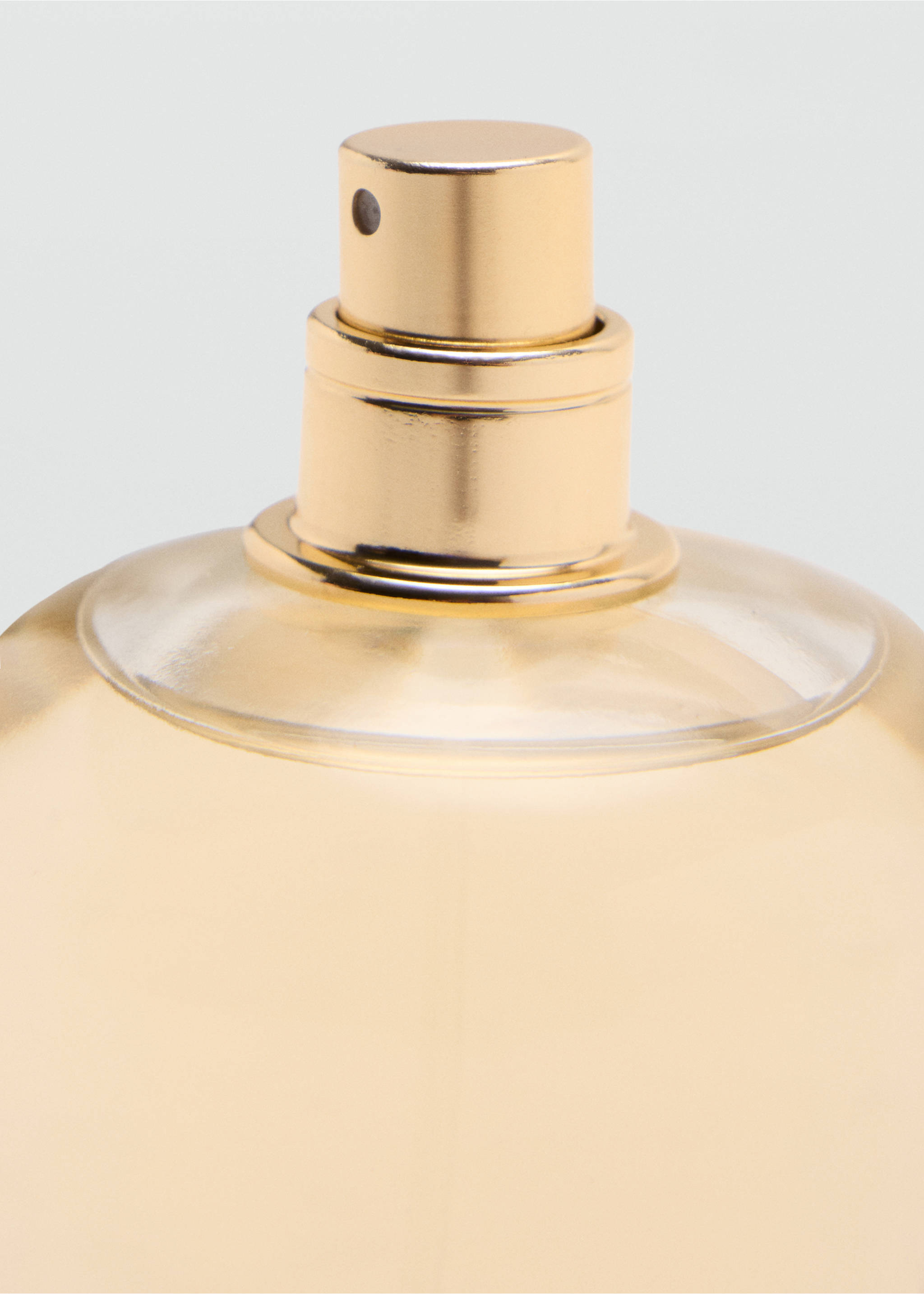 Close-up of a perfume bottle with a metallic gold spray nozzle., Mink Grey. Ref: 47001457-00.