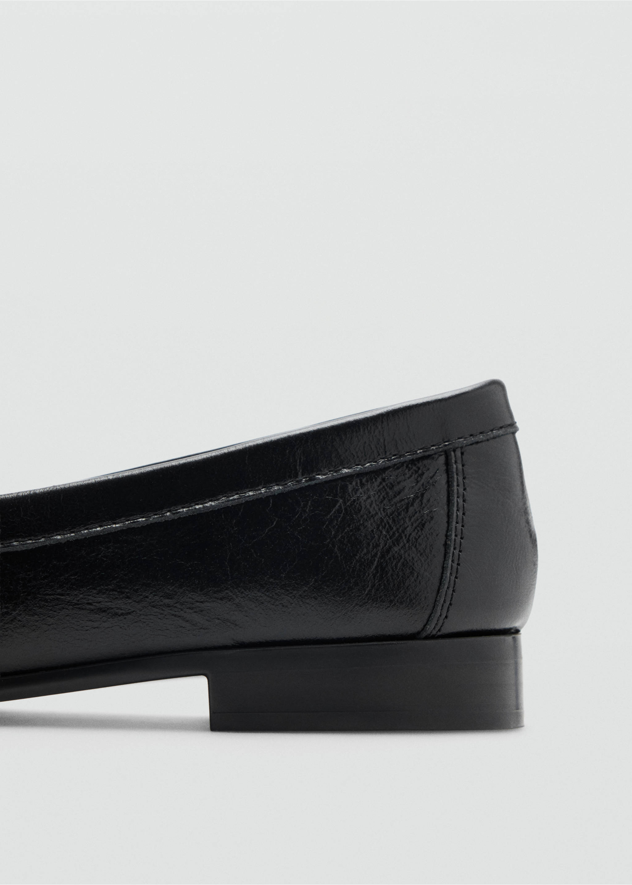 Close-up of the heel detail on a black flat shoe., Black. Ref: 47011342-00.