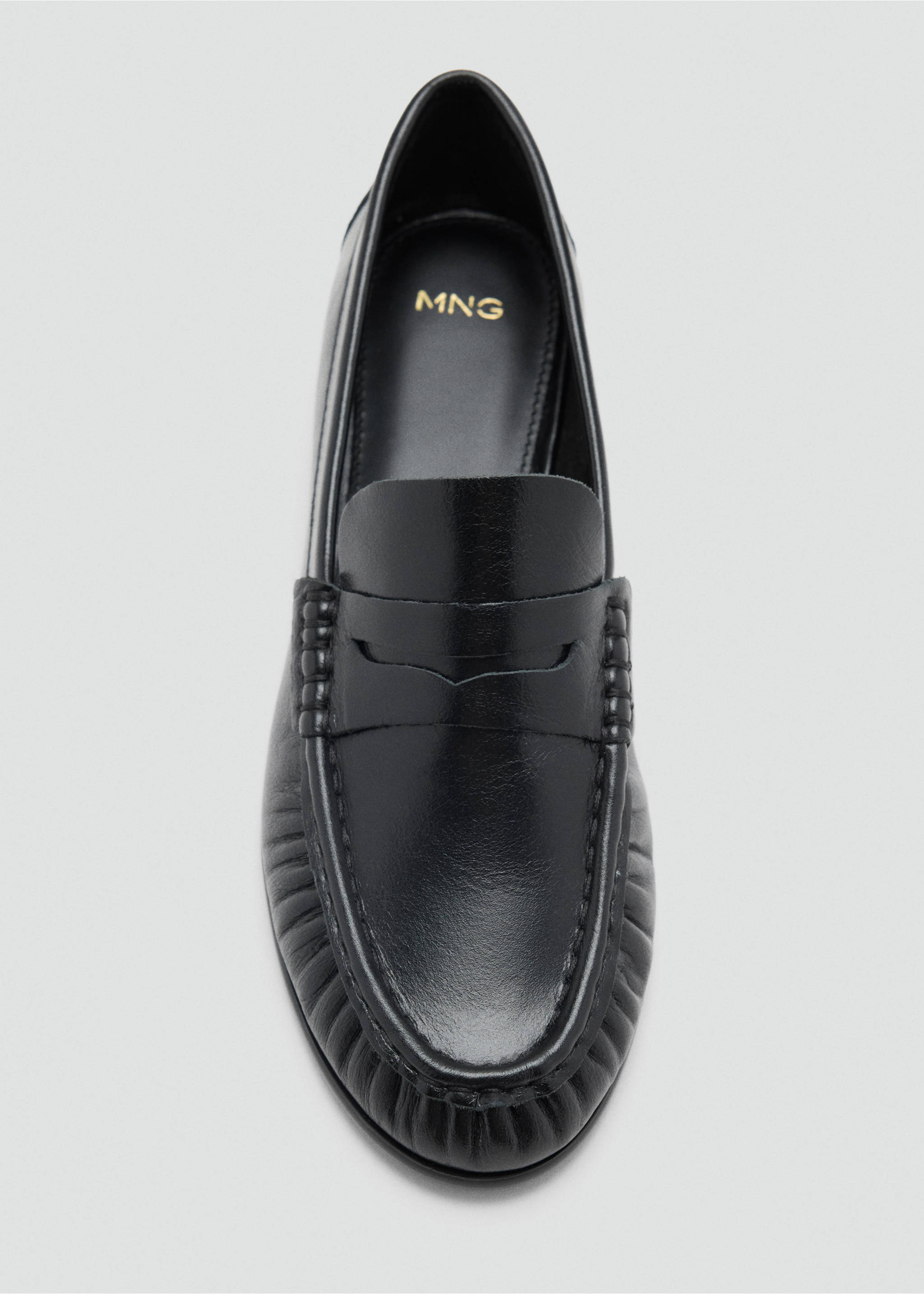 Black leather flat shoe featuring a traditional penny strap and ridged apron seam detail., Black. Ref: 47011342-00.