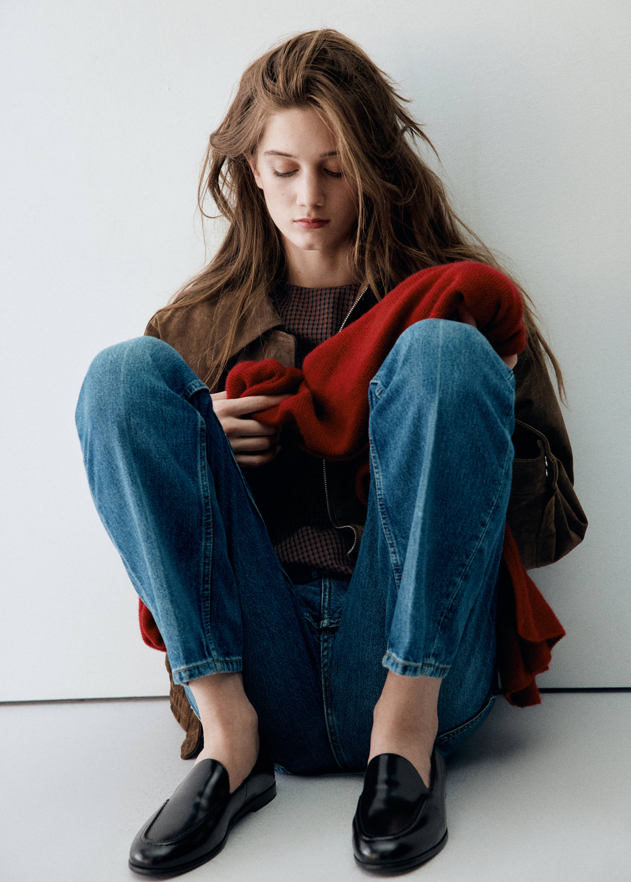 Mocasines de piel negros combinados con unos pantalones vaqueros azules.